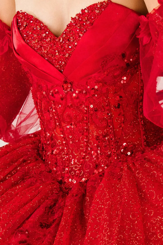 Bodice close-up of a red kids quinceañera dress showing glitter floral embroidery, sequins, and beadwork details.