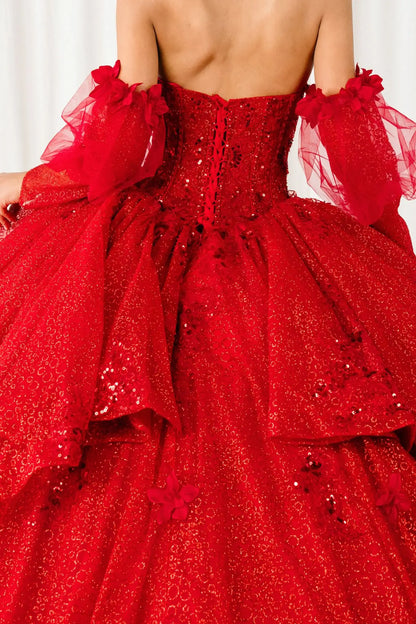 Back view of a red quinceañera dress with voluminous glitter tulle skirt, lace-up corset closure, and floral applique embellishments.