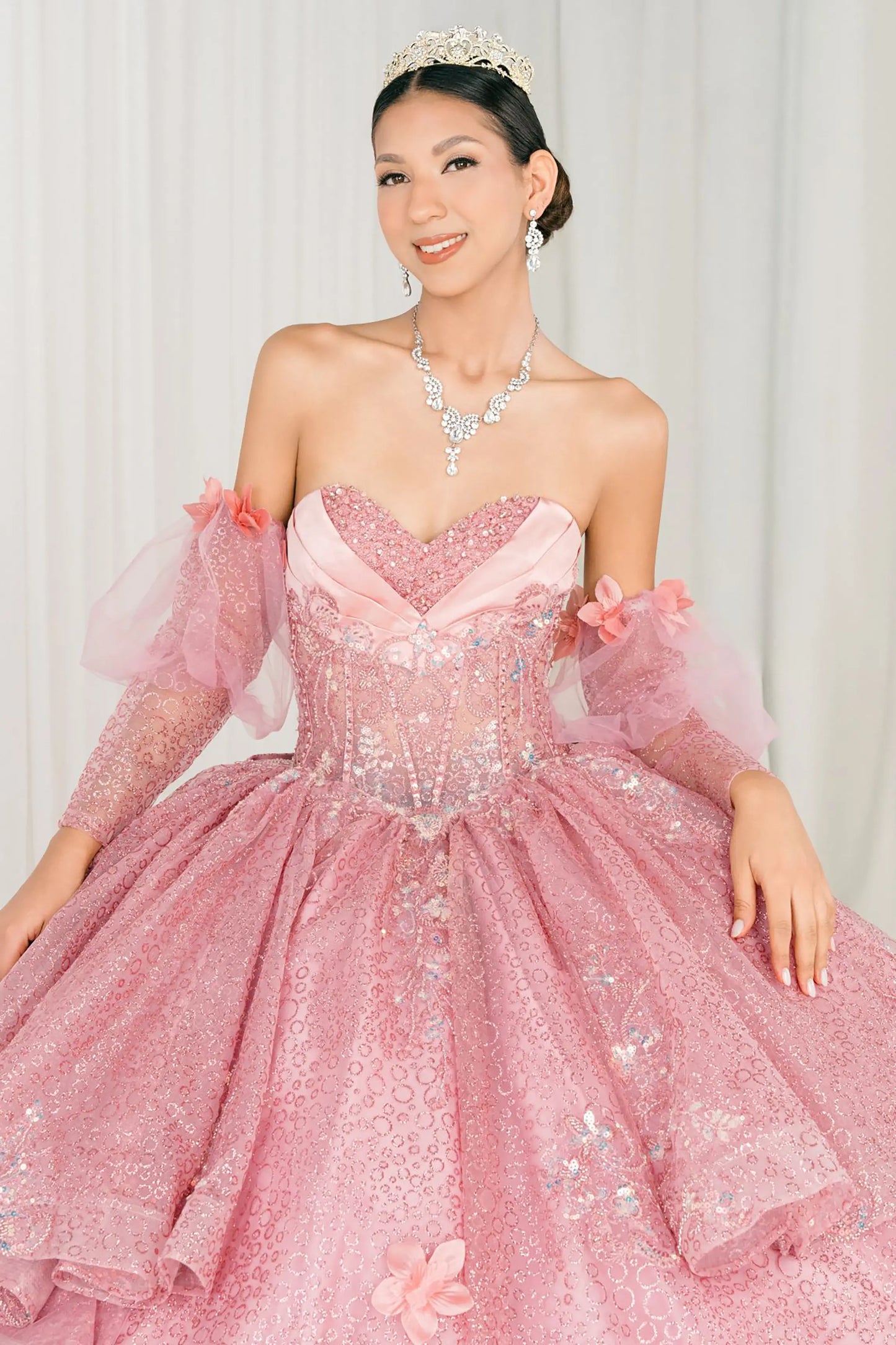Front full-length view of Dusty Rose quinceañera ball gown with off shoulder tulle sleeves, sweetheart sequin bodice, layered glitter tulle skirt, and cathedral train