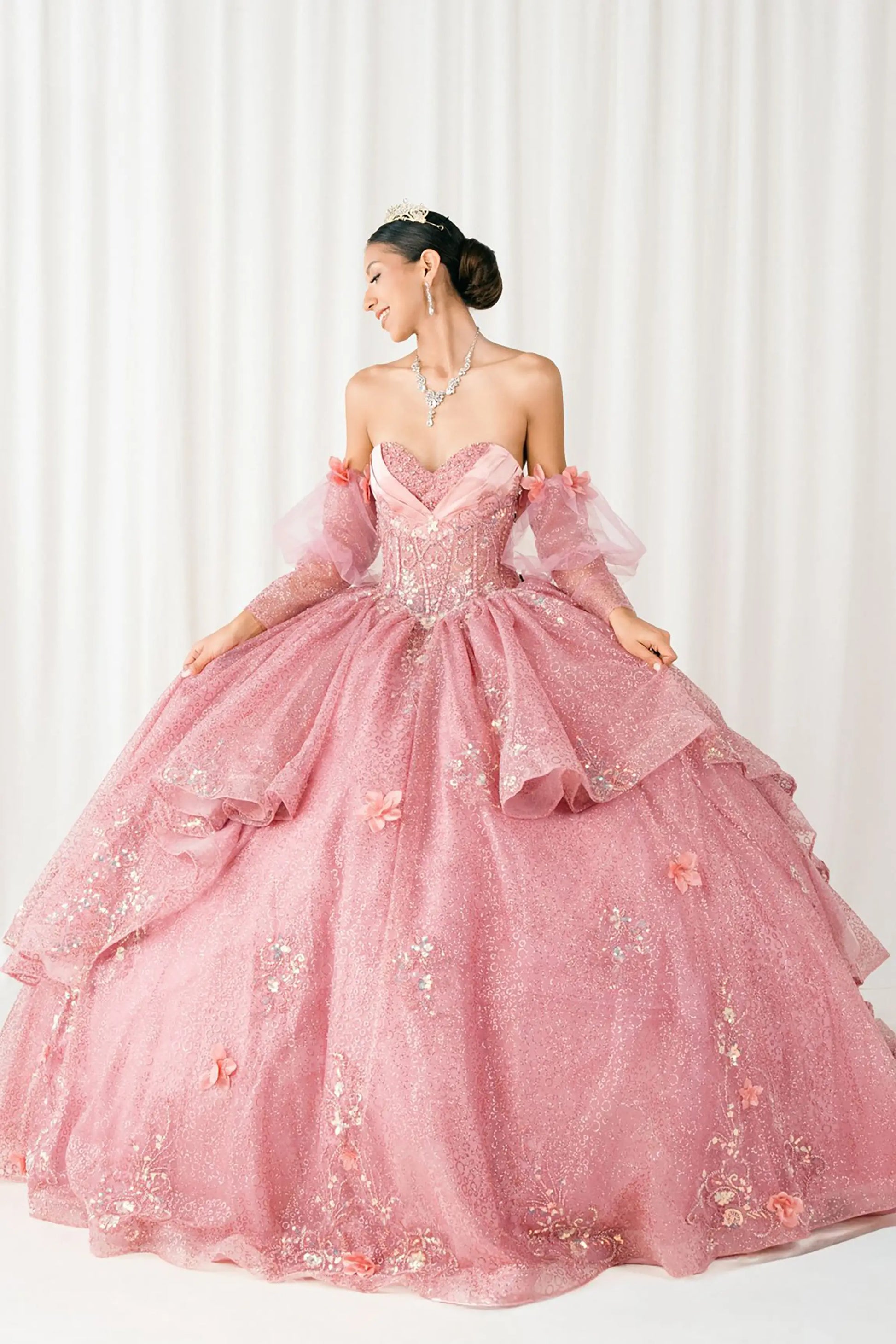 Front full-length view of Dusty Rose quinceañera ball gown with off shoulder tulle sleeves, sweetheart sequin bodice, layered glitter tulle skirt, and cathedral train