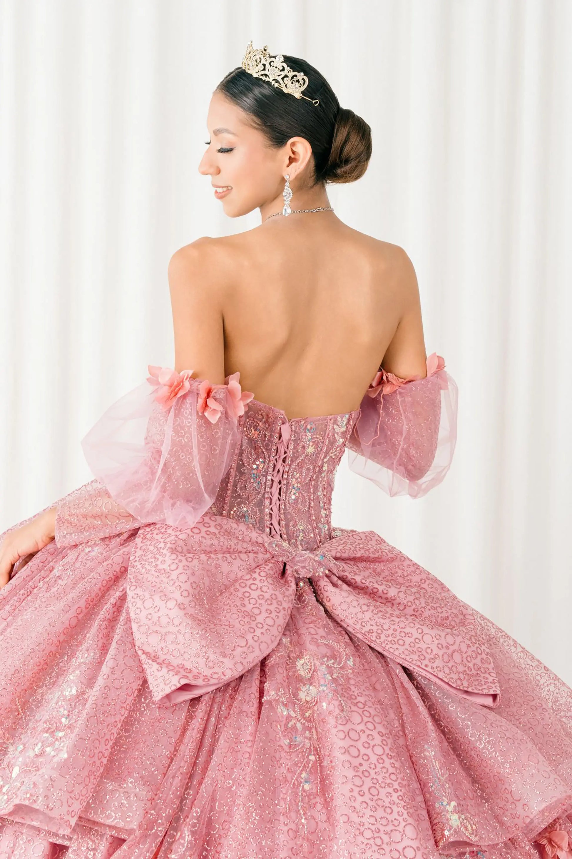 Back close-up Dusty Rose quinceañera ball gown with off shoulder tulle sleeves, sweetheart sequin bodice, layered glitter tulle skirt, and cathedral train