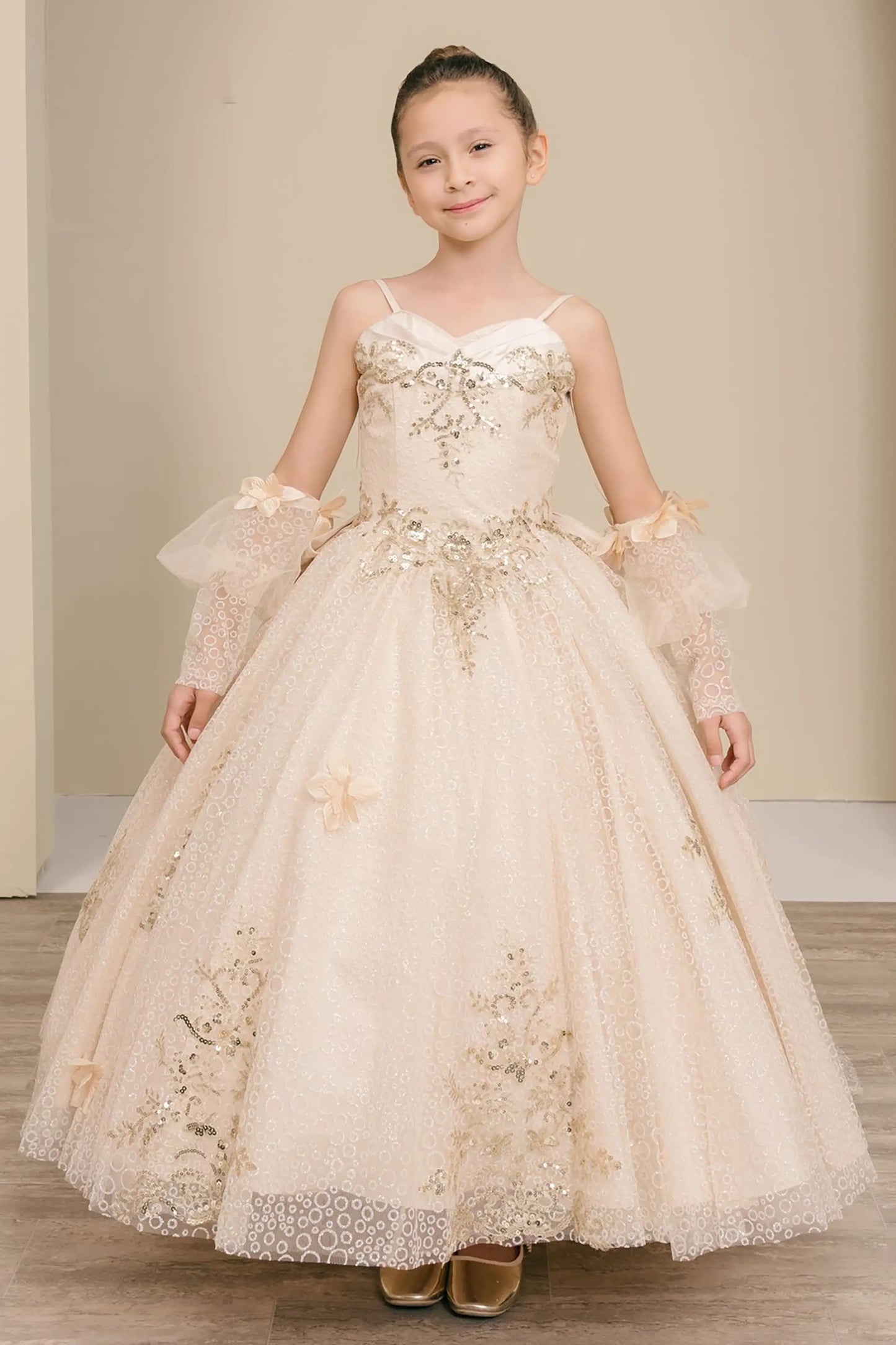 Front full-length view of Champagne mini quince ball gown with glitter floral embroidered bodice, full skirt, lace up back, oversized bow, and sheer lace gloves