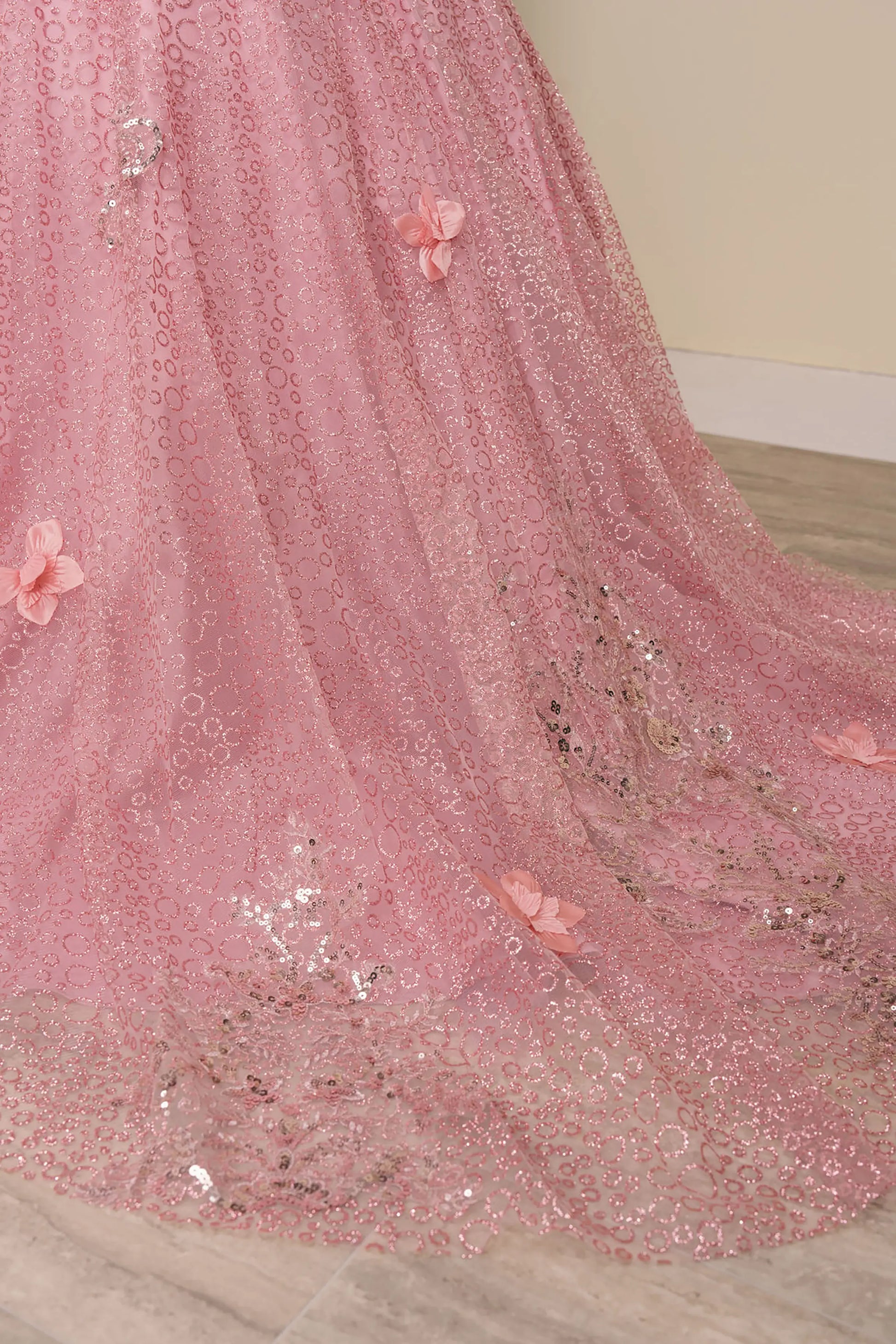 Close up view of Dusty Rose mini quince ball gown with glitter floral embroidered bodice, full skirt, lace up back, oversized bow, and sheer lace gloves