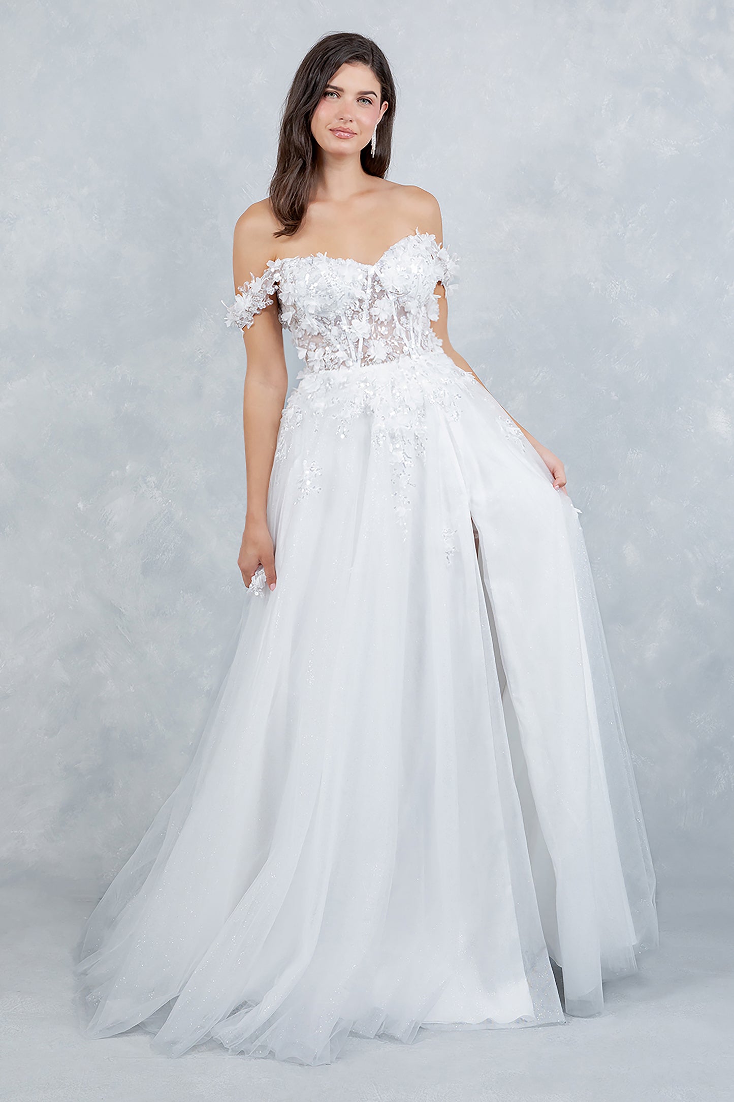 Woman wearing a white strapless gown with floral lace details on a light gray background