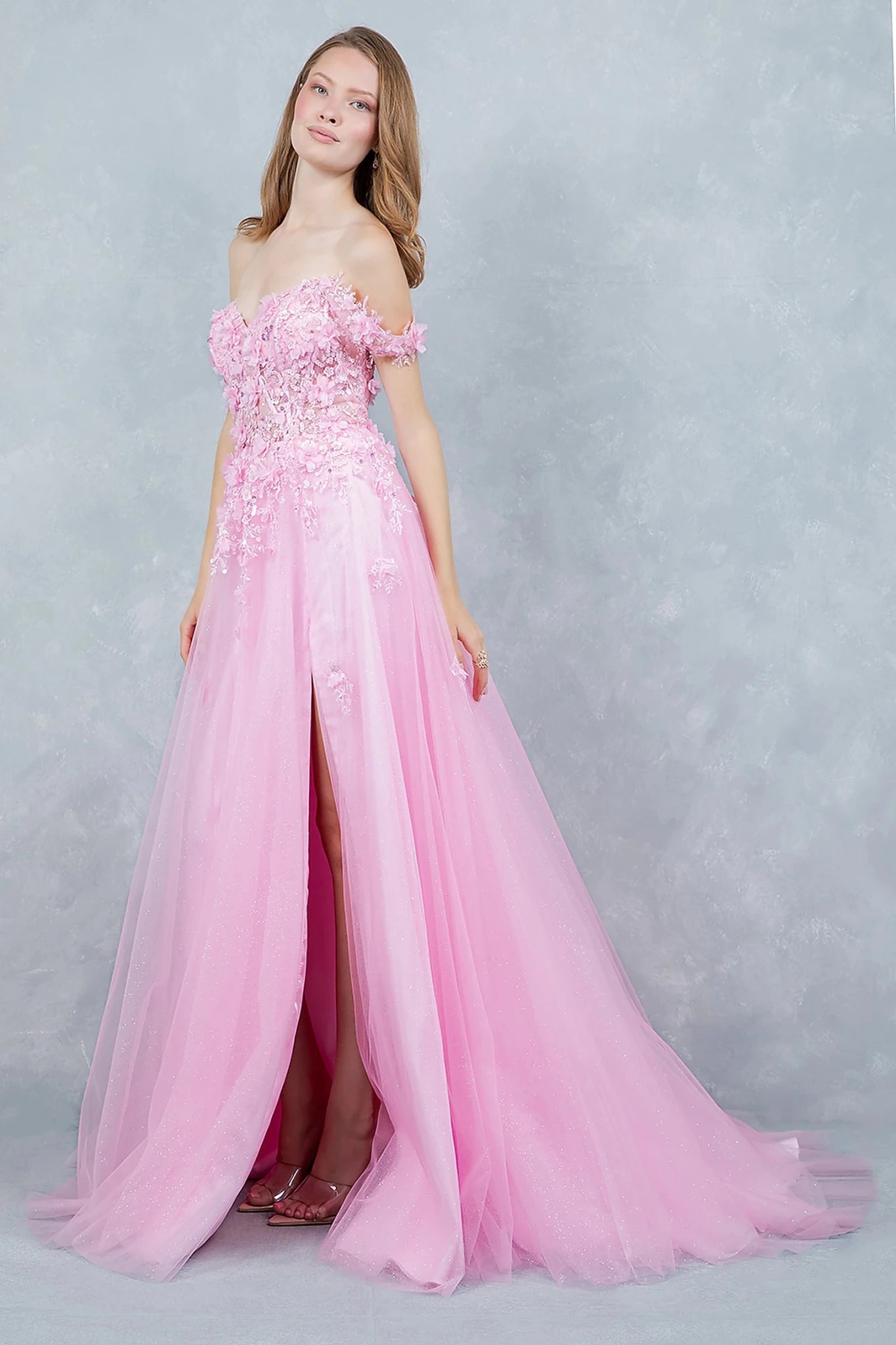 Pink prom dress designed with front slit adding soft movement to flowing silhouette