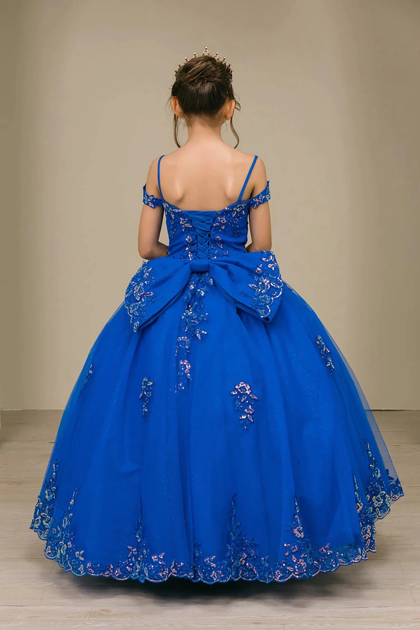 Back full-length view of Royal mini quince off shoulder mini quince dress with embroidered bodice, gemstone accent, glitter tulle skirt, lace up back, and oversized boW.