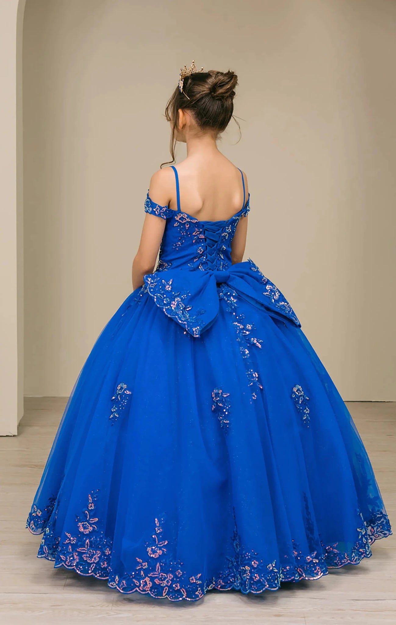 Back full-length view of Royal mini quince off shoulder mini quince dress with embroidered bodice, gemstone accent, glitter tulle skirt, lace up back, and oversized bow.