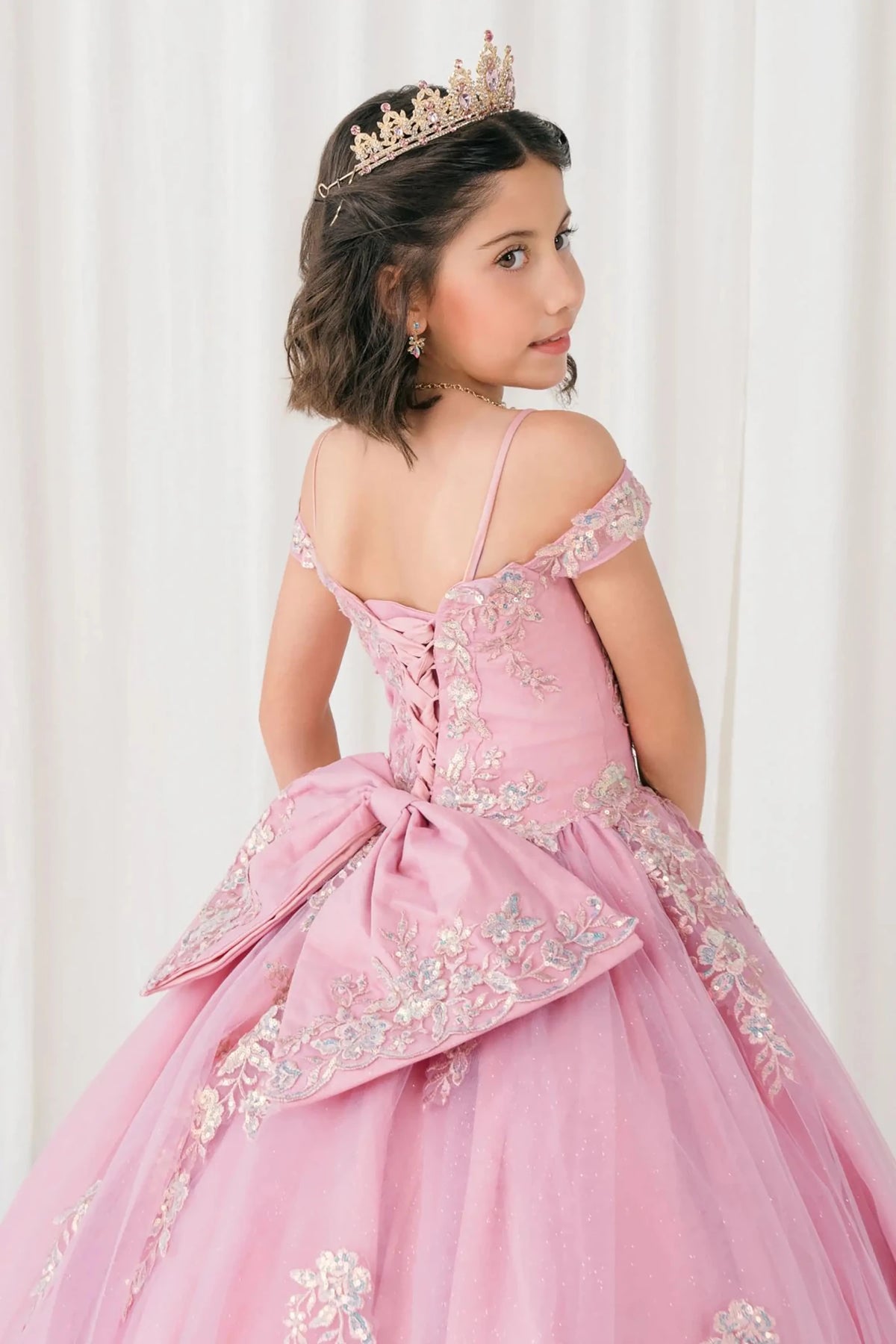 Back close-up Dusty Rose mini quince off shoulder mini quince dress with embroidered bodice, gemstone accent, glitter tulle skirt, lace up back, and oversized bow.