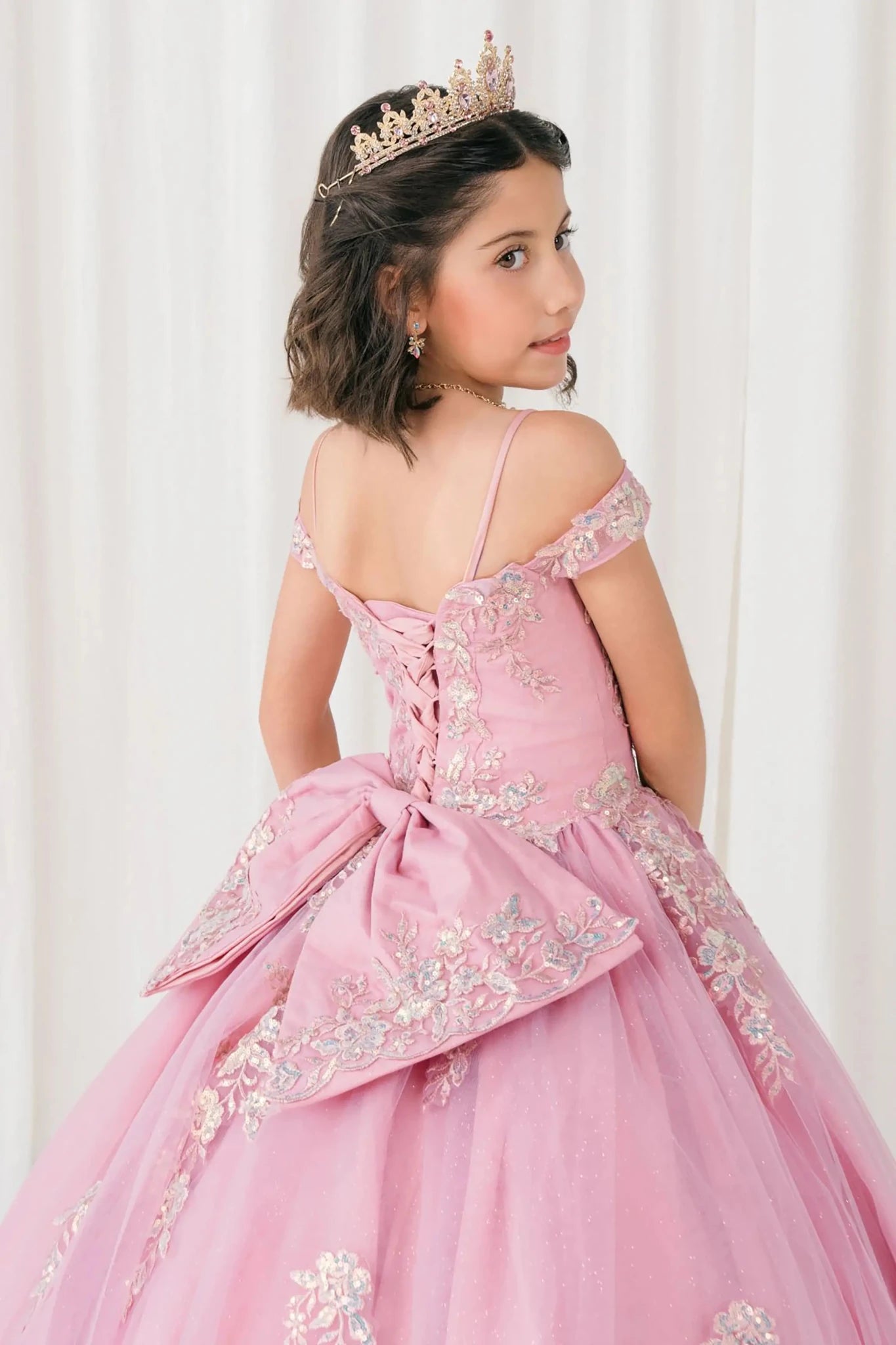 Back close-up Dusty Rose mini quince off shoulder mini quince dress with embroidered bodice, gemstone accent, glitter tulle skirt, lace up back, and oversized bow.