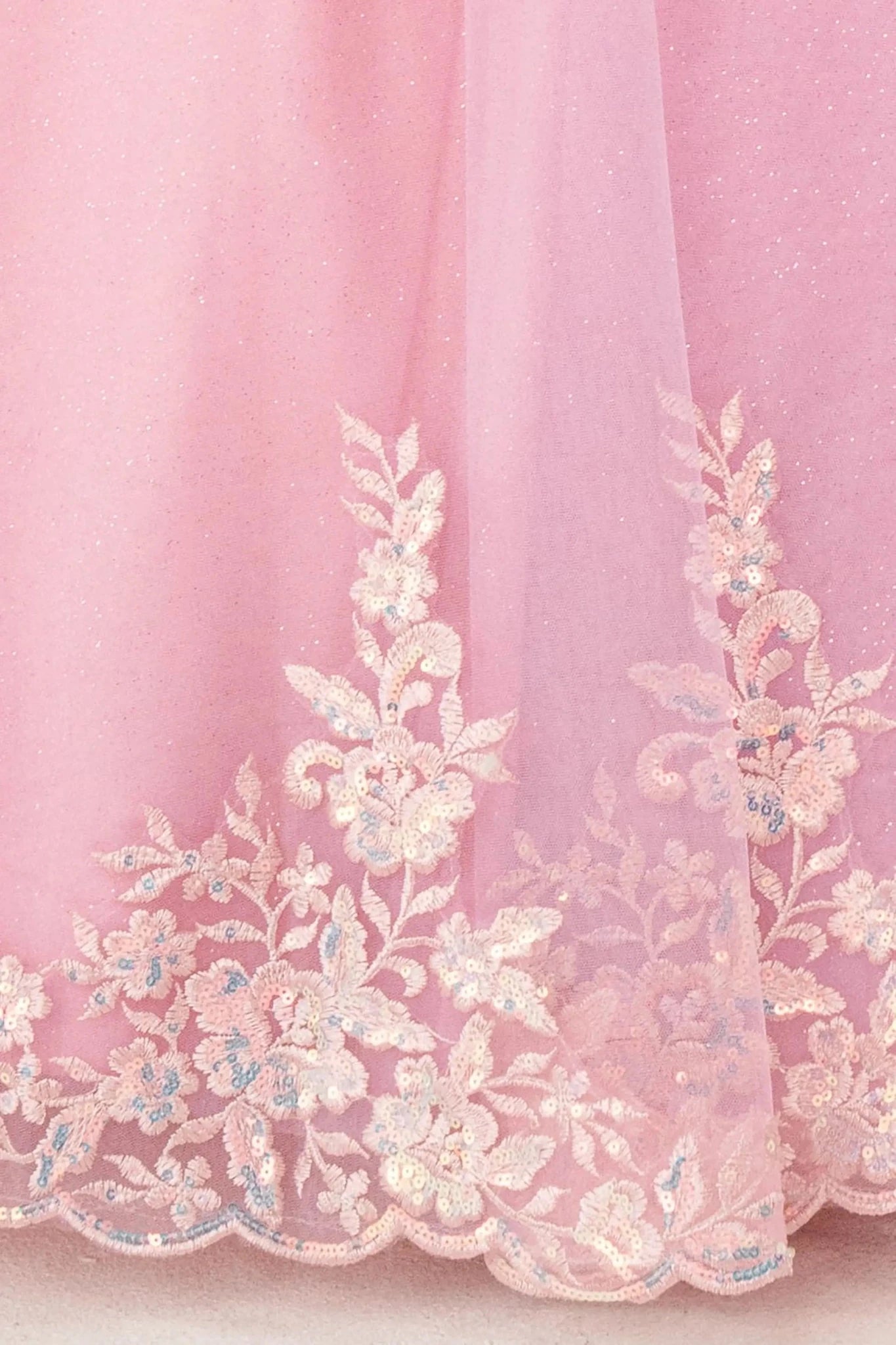 Close up Dusty Rose mini quince off shoulder mini quince dress with embroidered bodice, gemstone accent, glitter tulle skirt details.