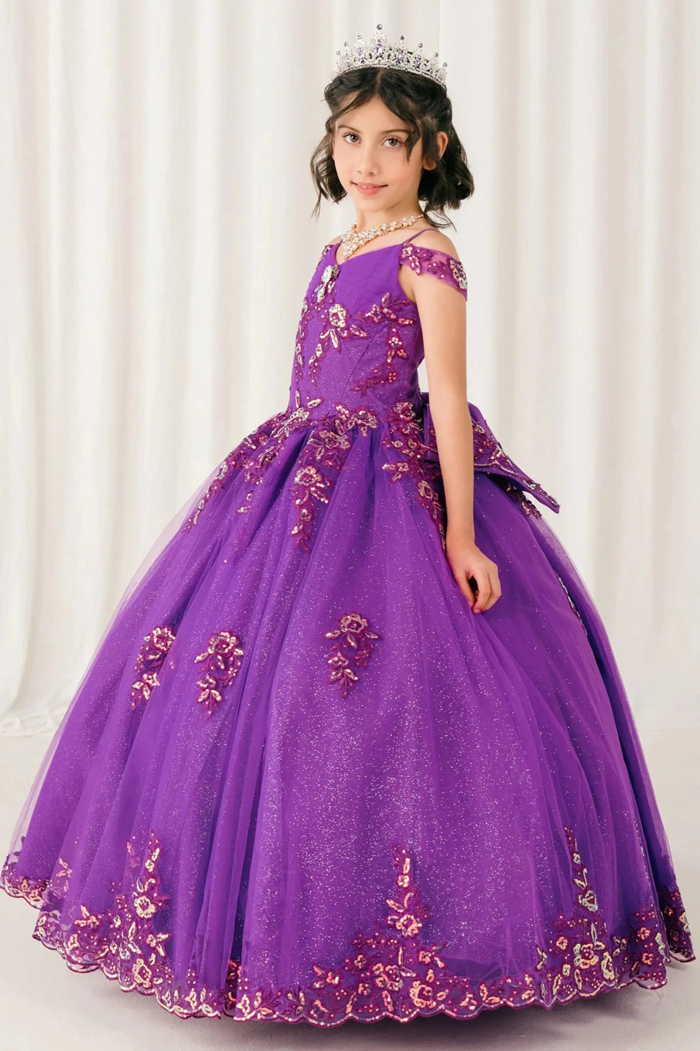 Side full-length view of Magenta Rose mini quince off shoulder mini quince dress with embroidered bodice, gemstone accent, glitter tulle skirt.