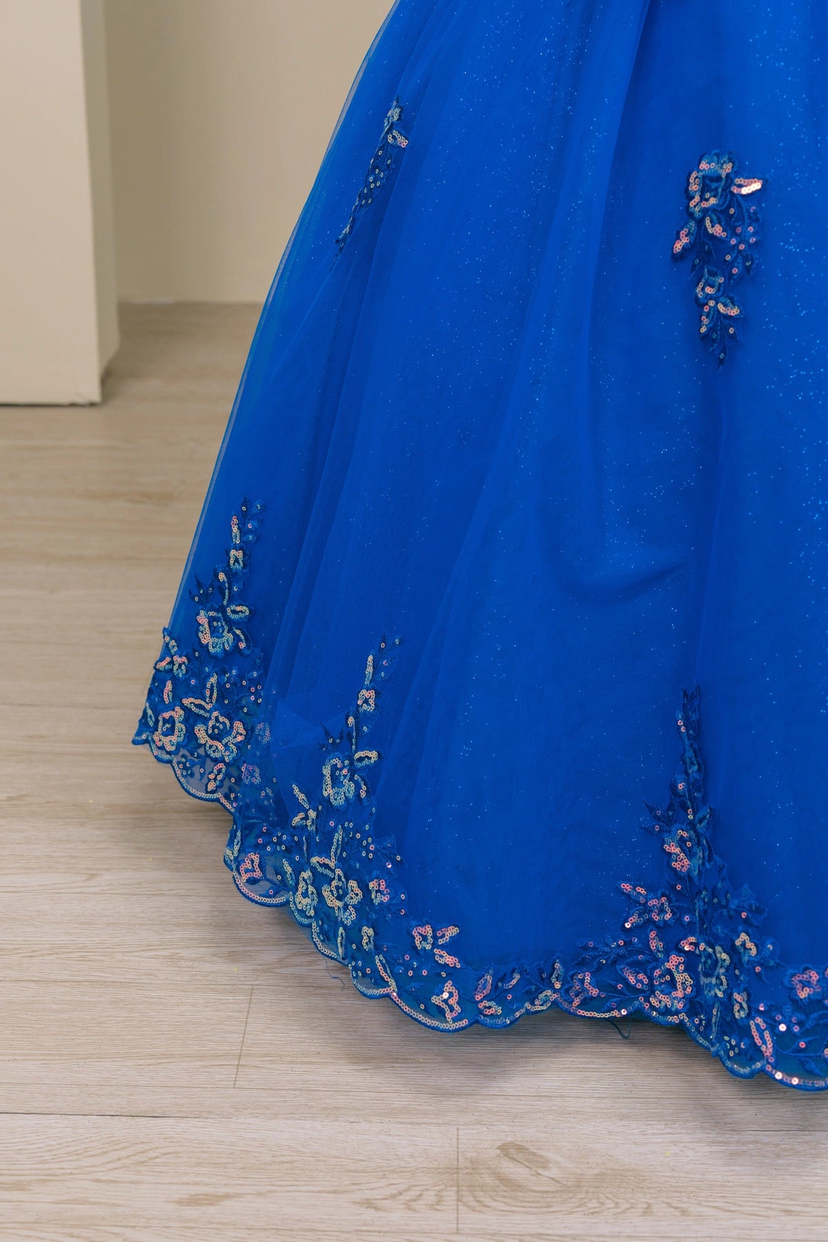 Shown in a skirt detail, the Blue (Royal) mini quince dress has floral lace appliques and a scalloped tulle hem.