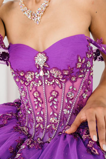 Front close-up view of Magenta Off shoulder quinceañera ball gown with beaded corset, floral appliqués, layered tulle skirt, cathedral length train, and bow