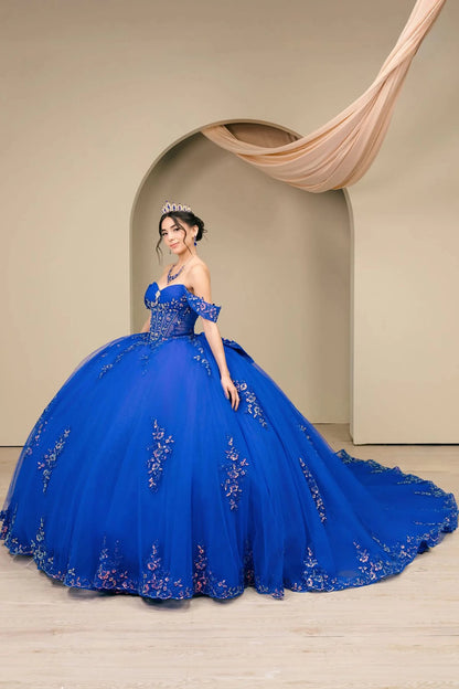 Side full-length view of Royal Off shoulder quinceañera ball gown with beaded corset, floral appliqués, layered tulle skirt, cathedral length train, and bow