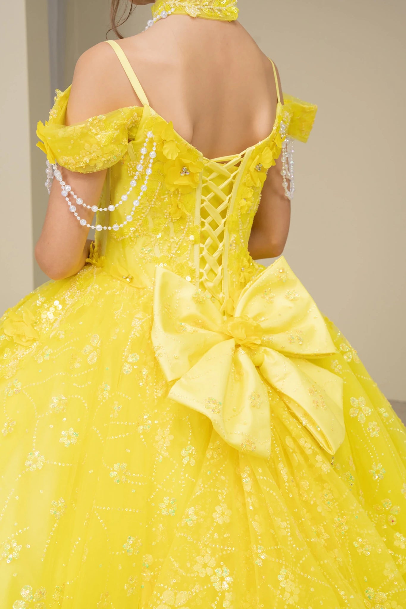Yellow front view kids mini quinceañera ball gown with floral lace, bow detail and glitter tulle skirt