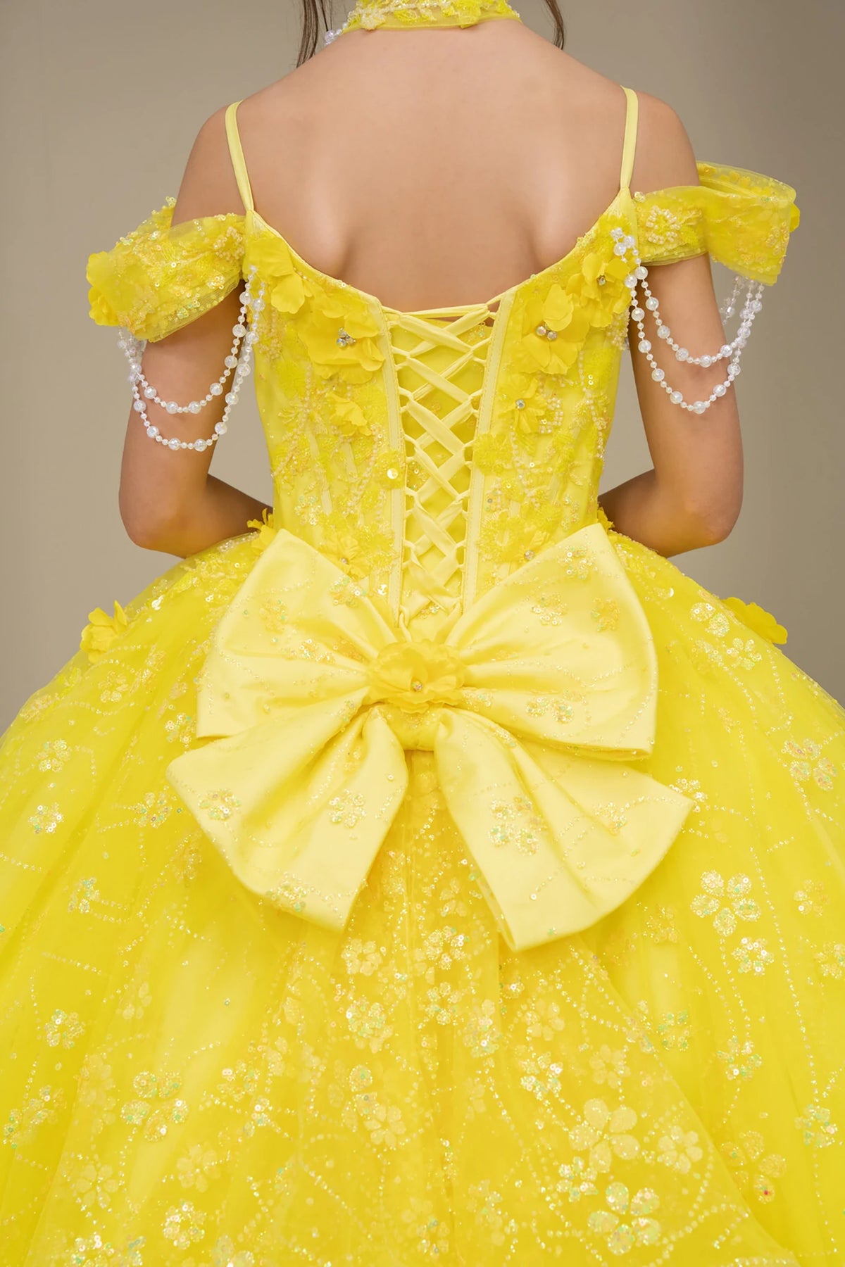 Yellow front view kids mini quinceañera mini quince dress with floral lace, large bow detail and glitter tulle skirt.