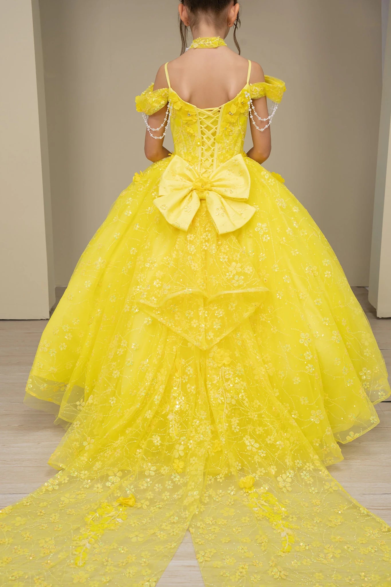 Yellow back view kids mini quinceañera mini quince dress with floral lace, long train and glitter tulle skirt.