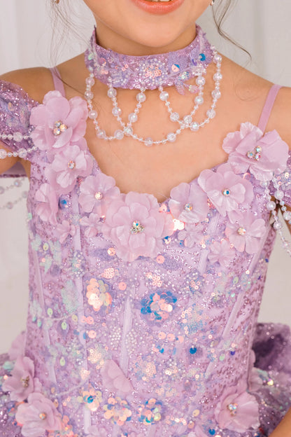 Close-up of a person wearing a sparkling lilac mini quince dress with floral details and jewelry.