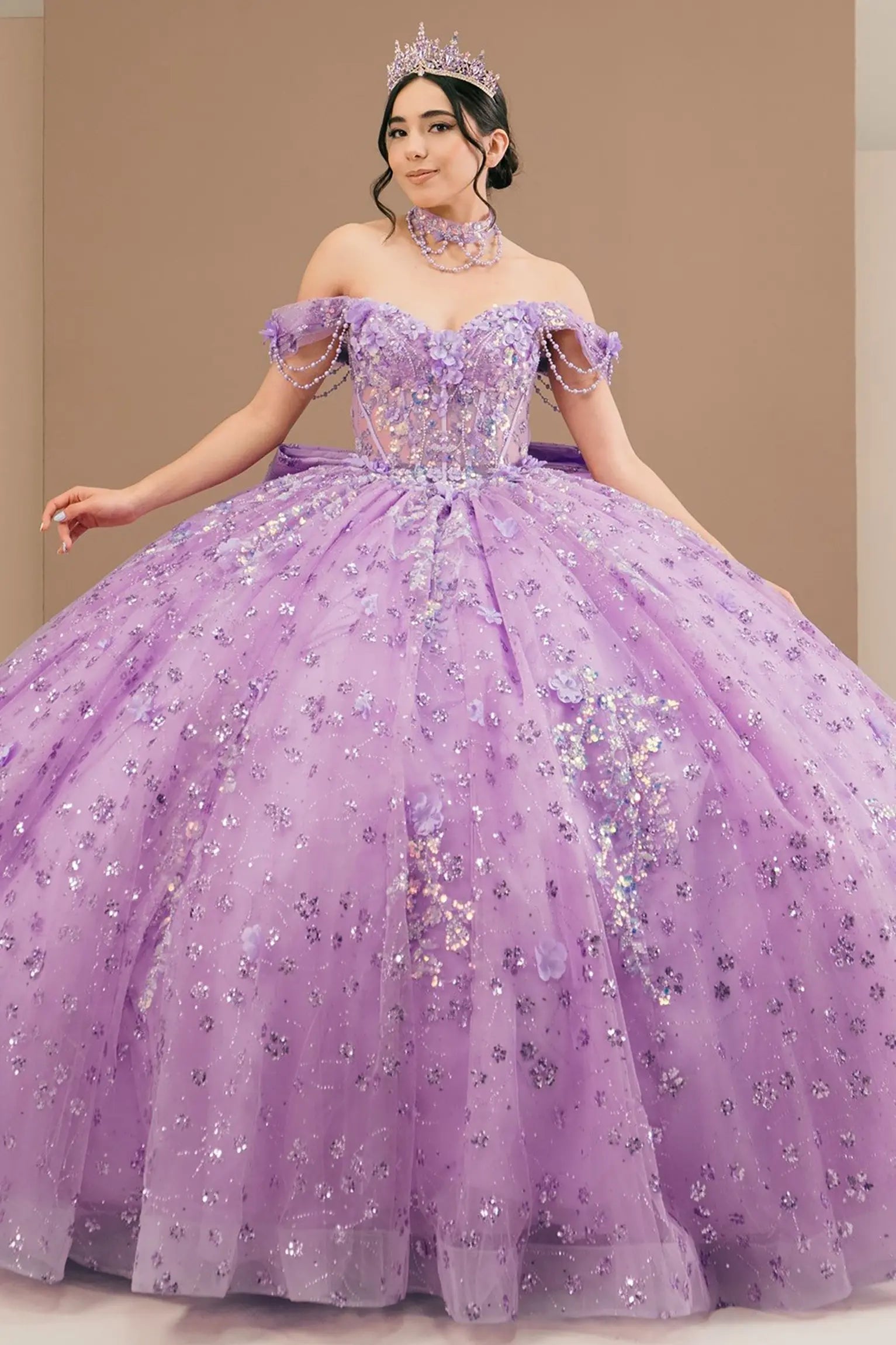 Full front view of a woman wearing lilac quinceañera dress with glitter tulle skirt, off-shoulder sweetheart neckline, and beaded corset bodice.