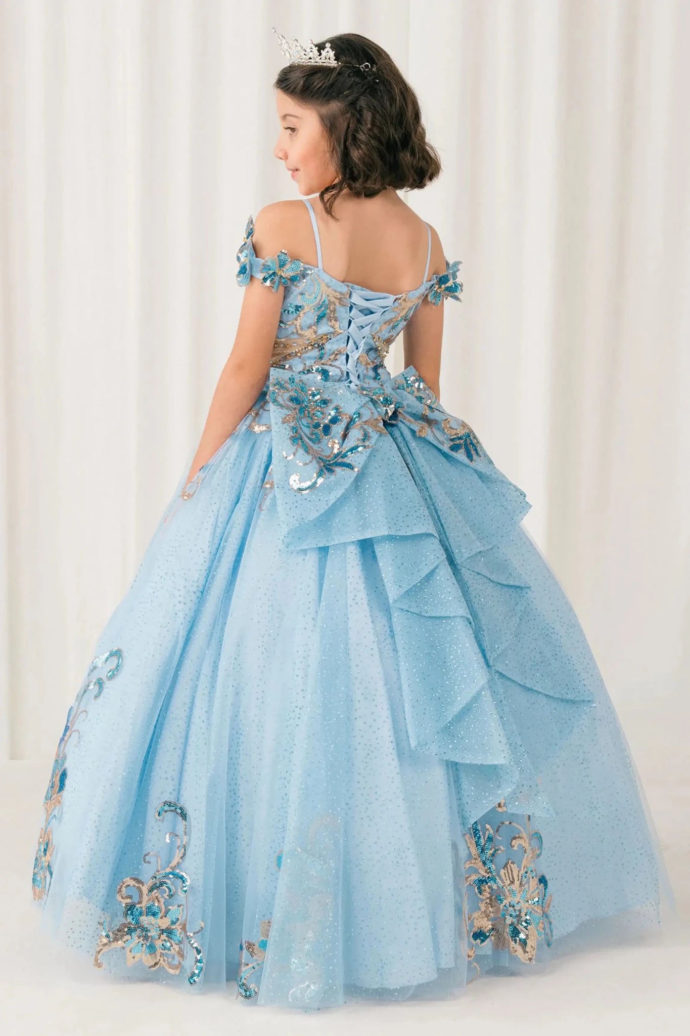 Black full-length view of Blue mini quince mini quince dress with off shoulder floral embroidered bodice, glitter tulle skirt, lace up back, and layered bow.