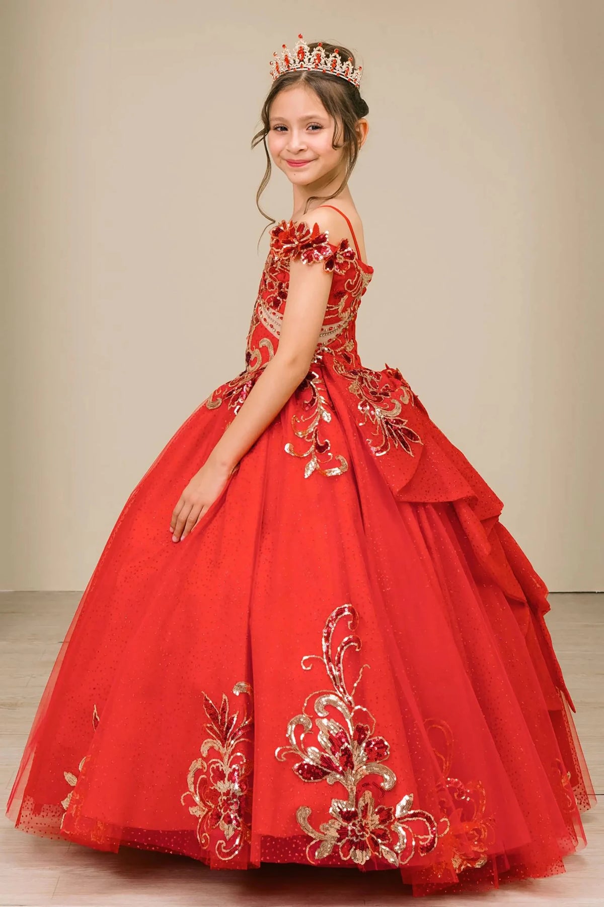 Side full-length view of Red mini quince mini quince dress with off shoulder floral embroidered bodice, glitter tulle skirt, lace up back, and layered bow.