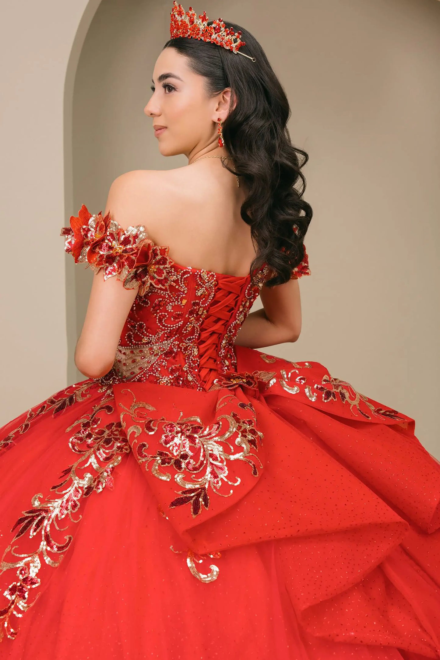 Black close-up Red quinceañera ball gown with off shoulder bodice, gold embroidery, floral appliqués, voluminous tulle skirt, corset back, and oversized bow