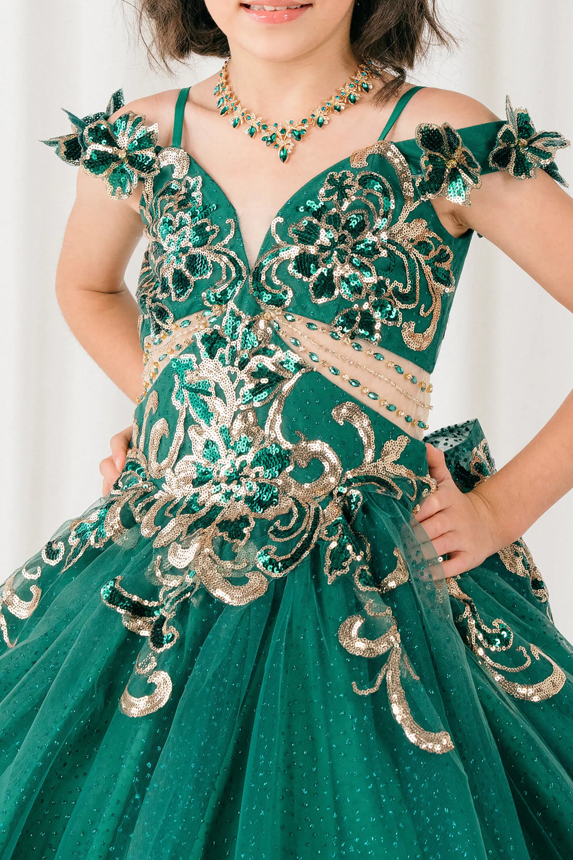 Front close up view of Hunter green mini quince ball gown with off shoulder floral embroidered bodice, glitter tulle skirt, lace up back, and layered bow