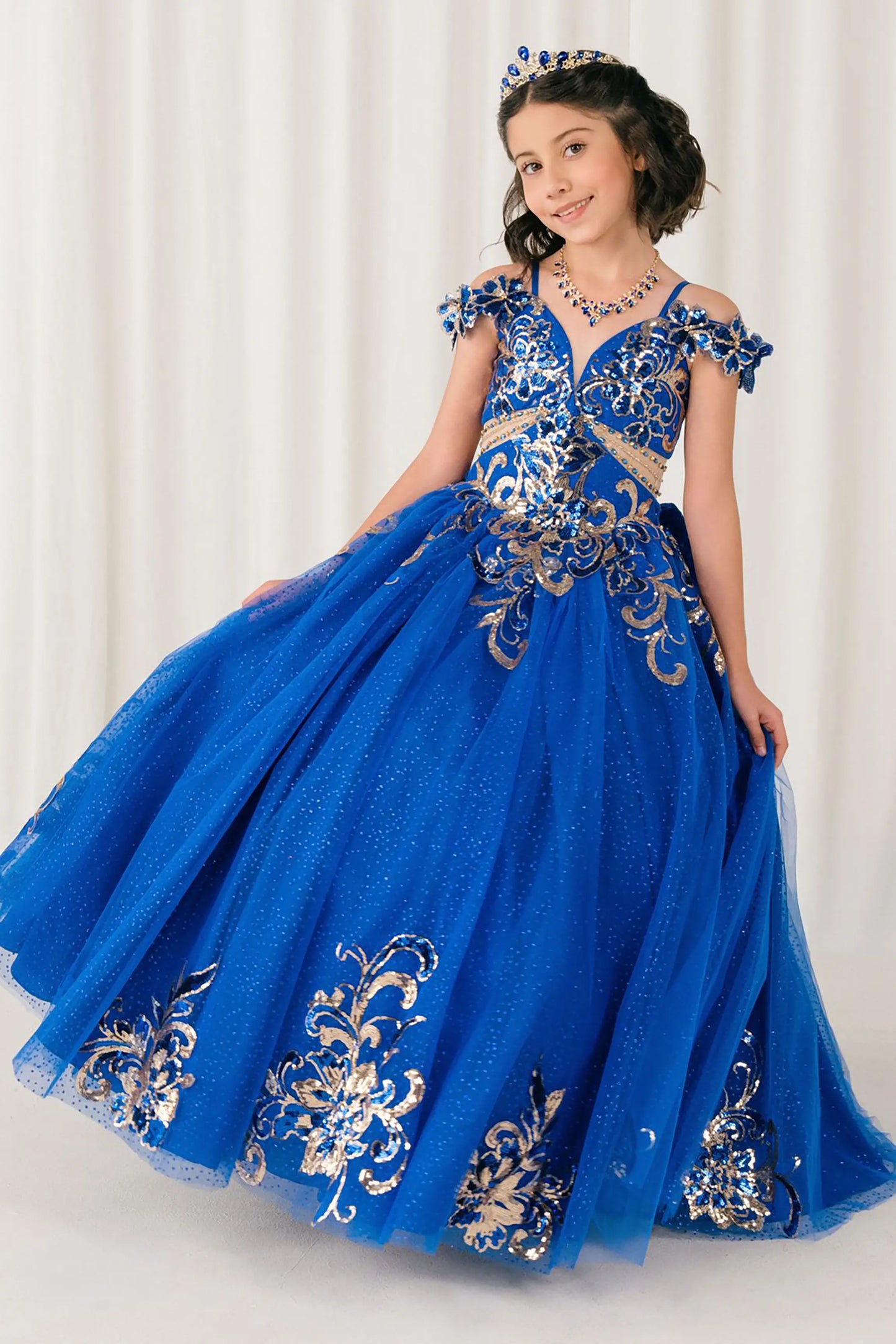 Front full-length view of Royal mini quince ball gown with off shoulder floral embroidered bodice, glitter tulle skirt, lace up back, and layered bow