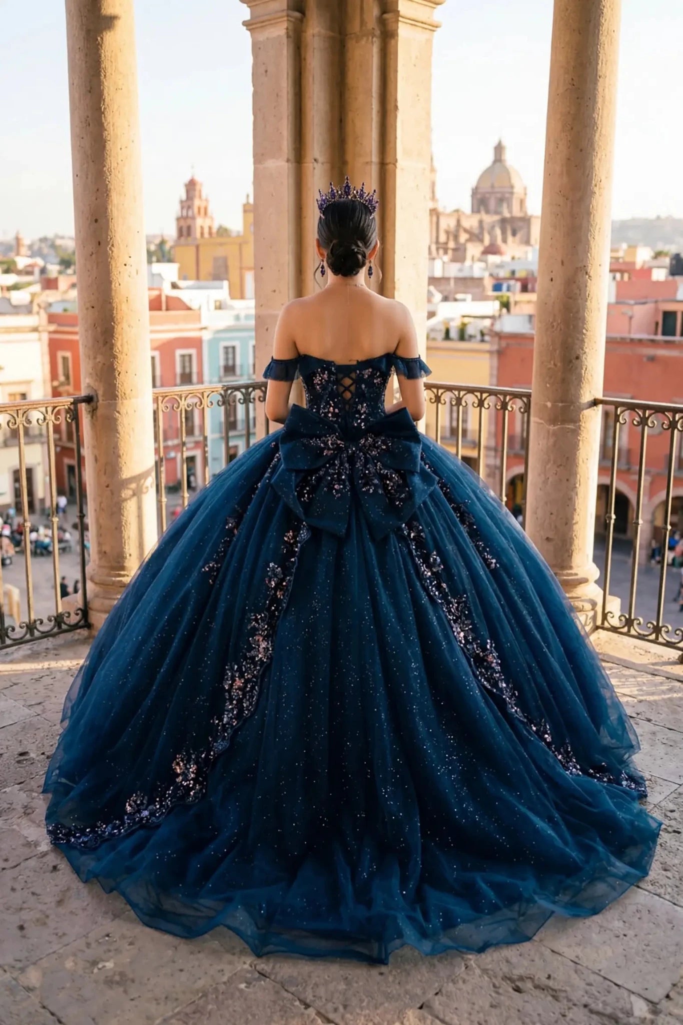 Woman wearing navy quinceañera royal dress back-facing with embroidered beaded corset bodice and  shimmering textured skirt