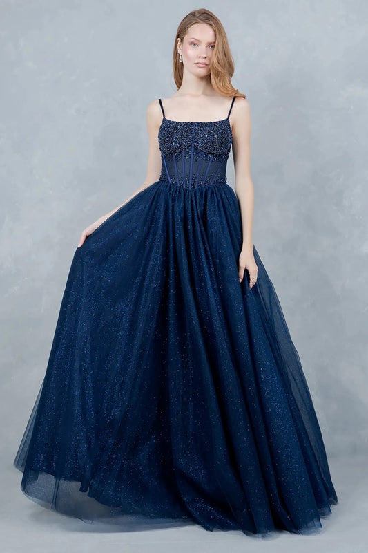 Full front view of a women wearing navy crystal corset prom dress with delicate straps and voluminous sparkling tulle skirt.