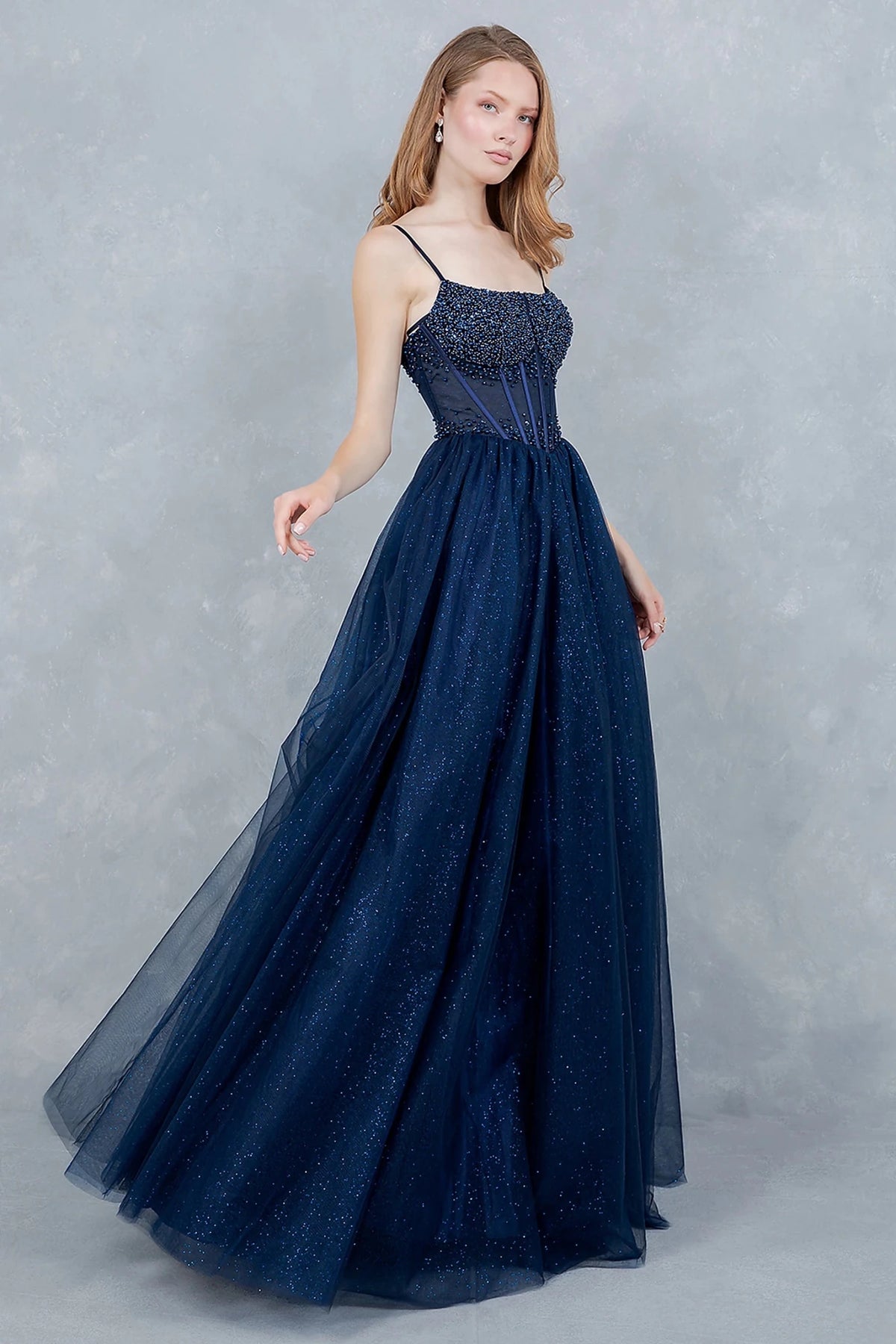 Navy evening dress showcasing voluminous tulle skirt sparkling like midnight sky