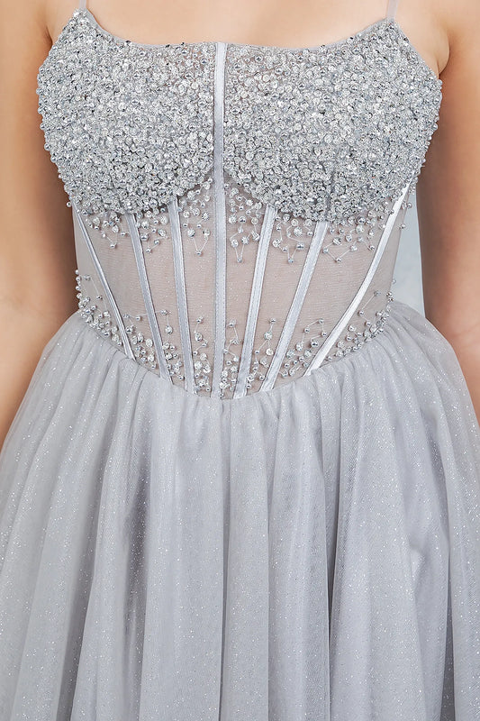 Silver evening dress featuring clustered embellishments cascading for sculpted effect