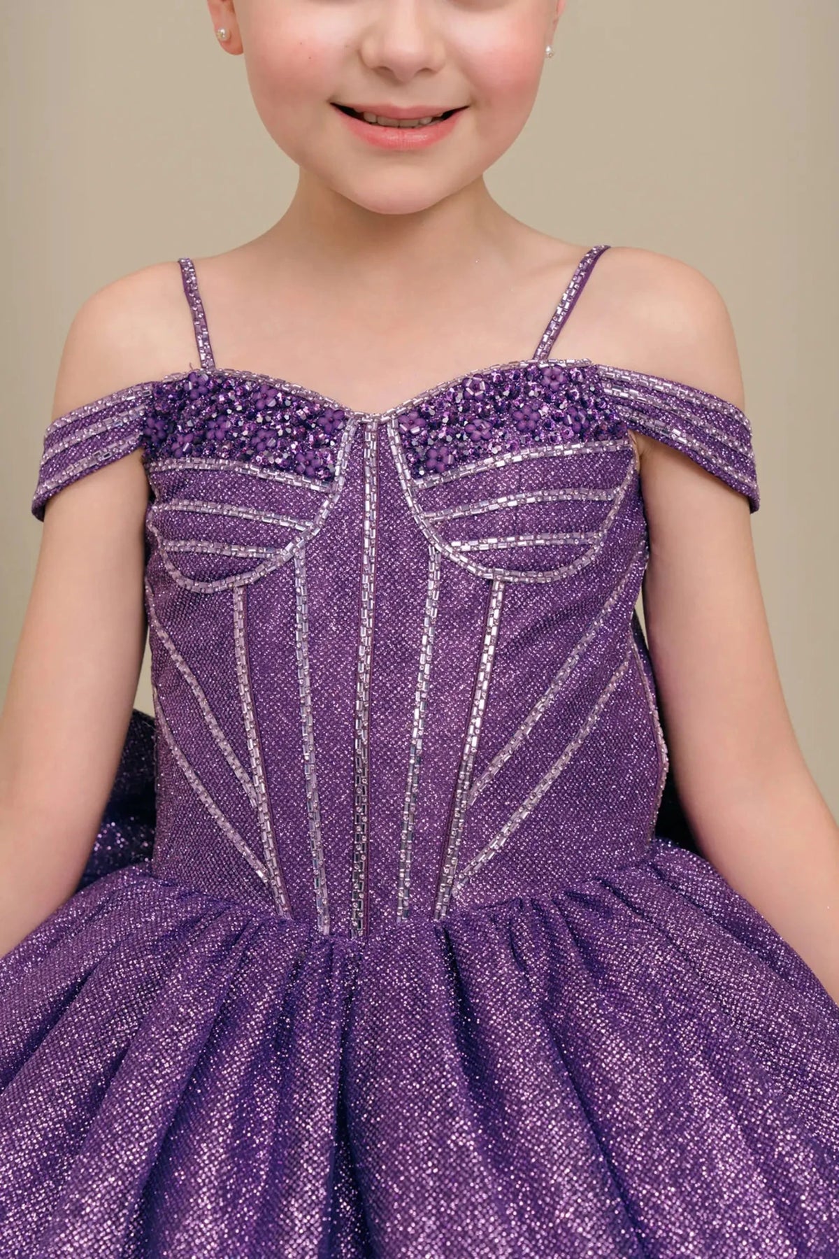 Close-up front-facing view of purple mini quince dress with embellished bodice and oversized tiered bow accent.