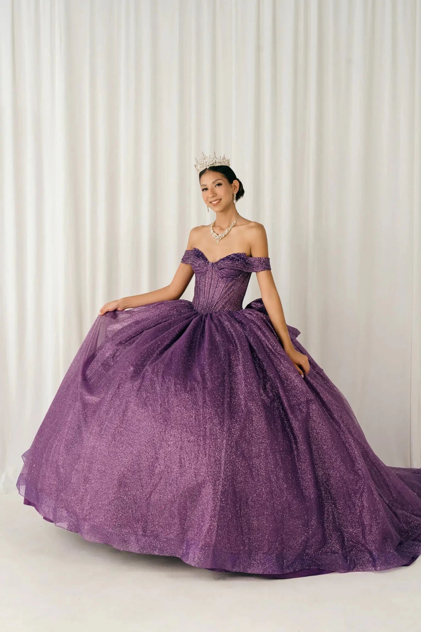 Woman standing front-facing in elegant purple ball gown with beaded corset bodice and voluminous glitter tulle skirt

