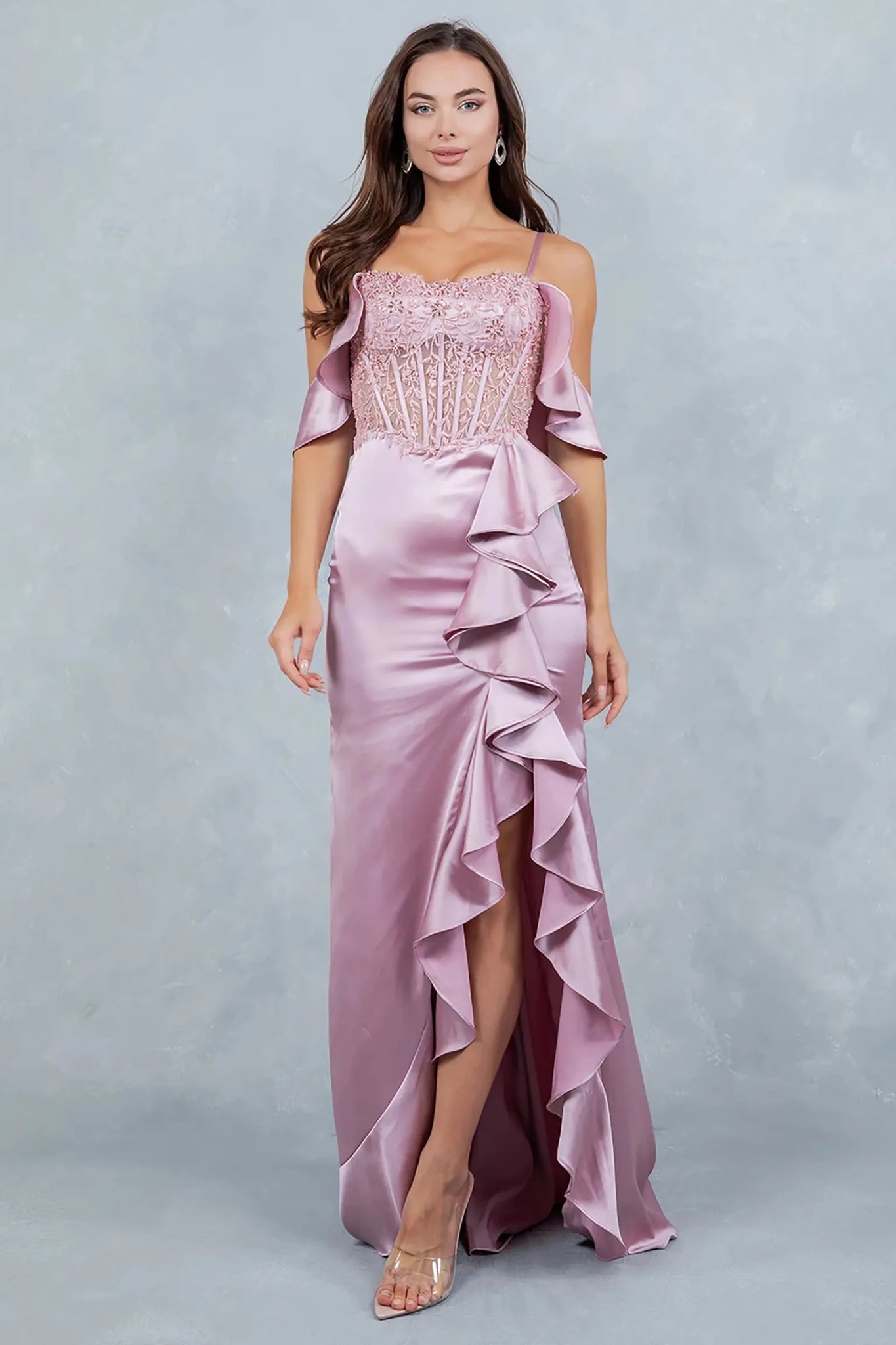 Full front view of a women wearing rose gold satin prom dress with lace corset bodice and ruffle slit.