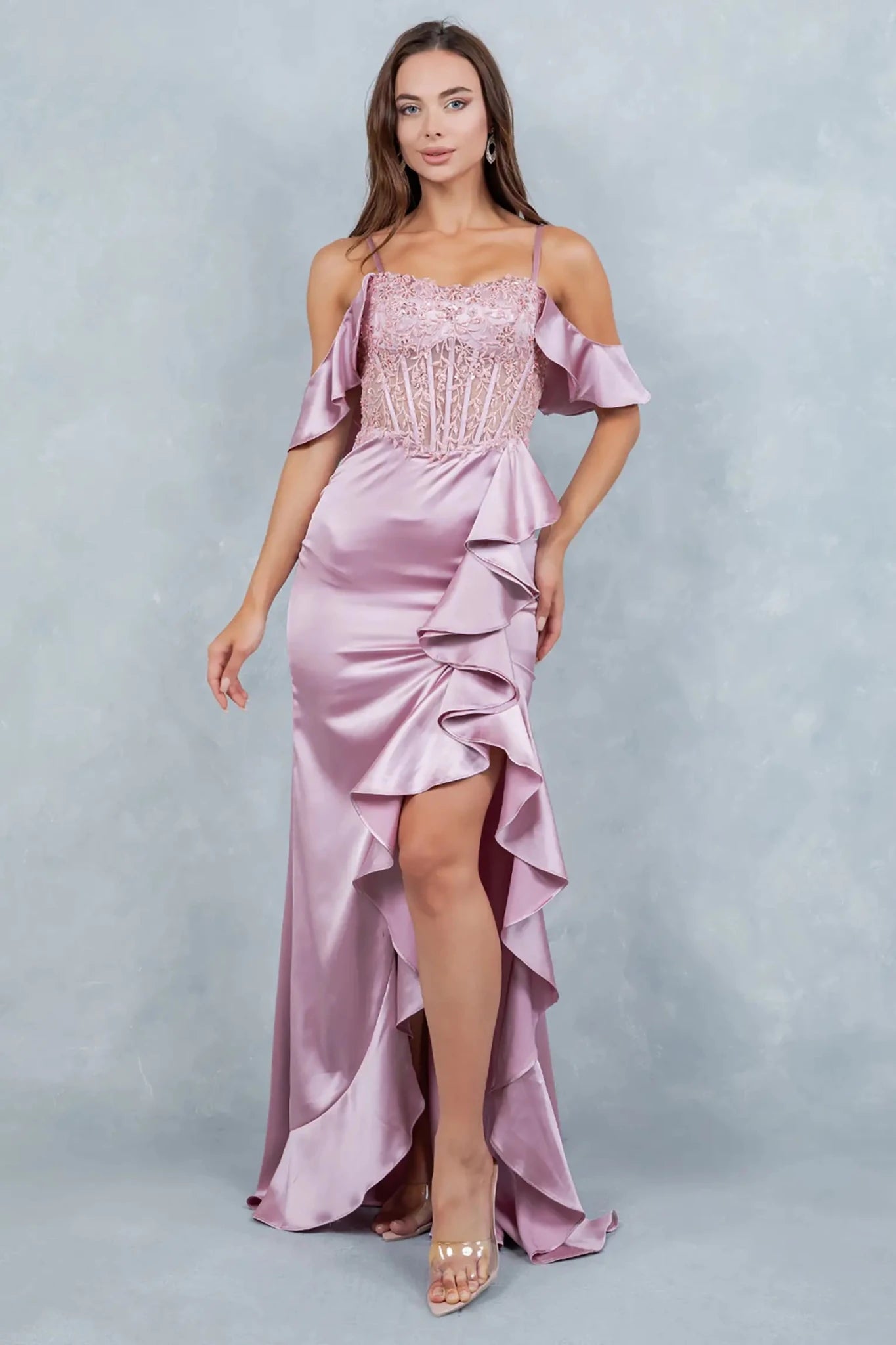 A full-length front view of a woman elegantly wearing a rose gold formal prom dress with a graceful, sweeping train.