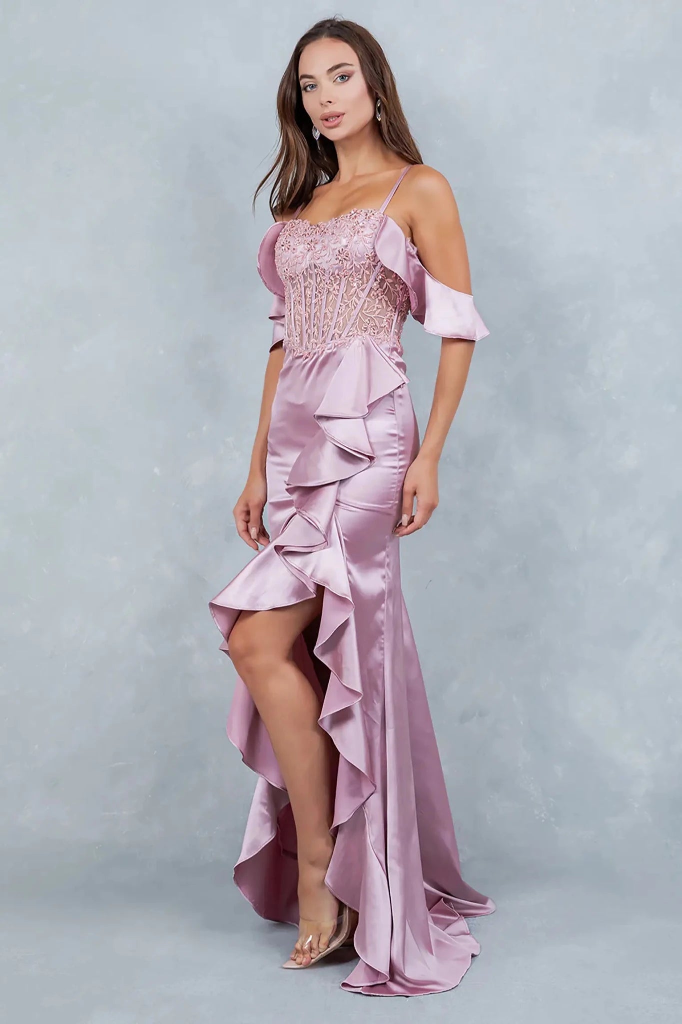 A side profile view of a woman wearing a rose gold satin prom dress, showcasing the sculpted silhouette.