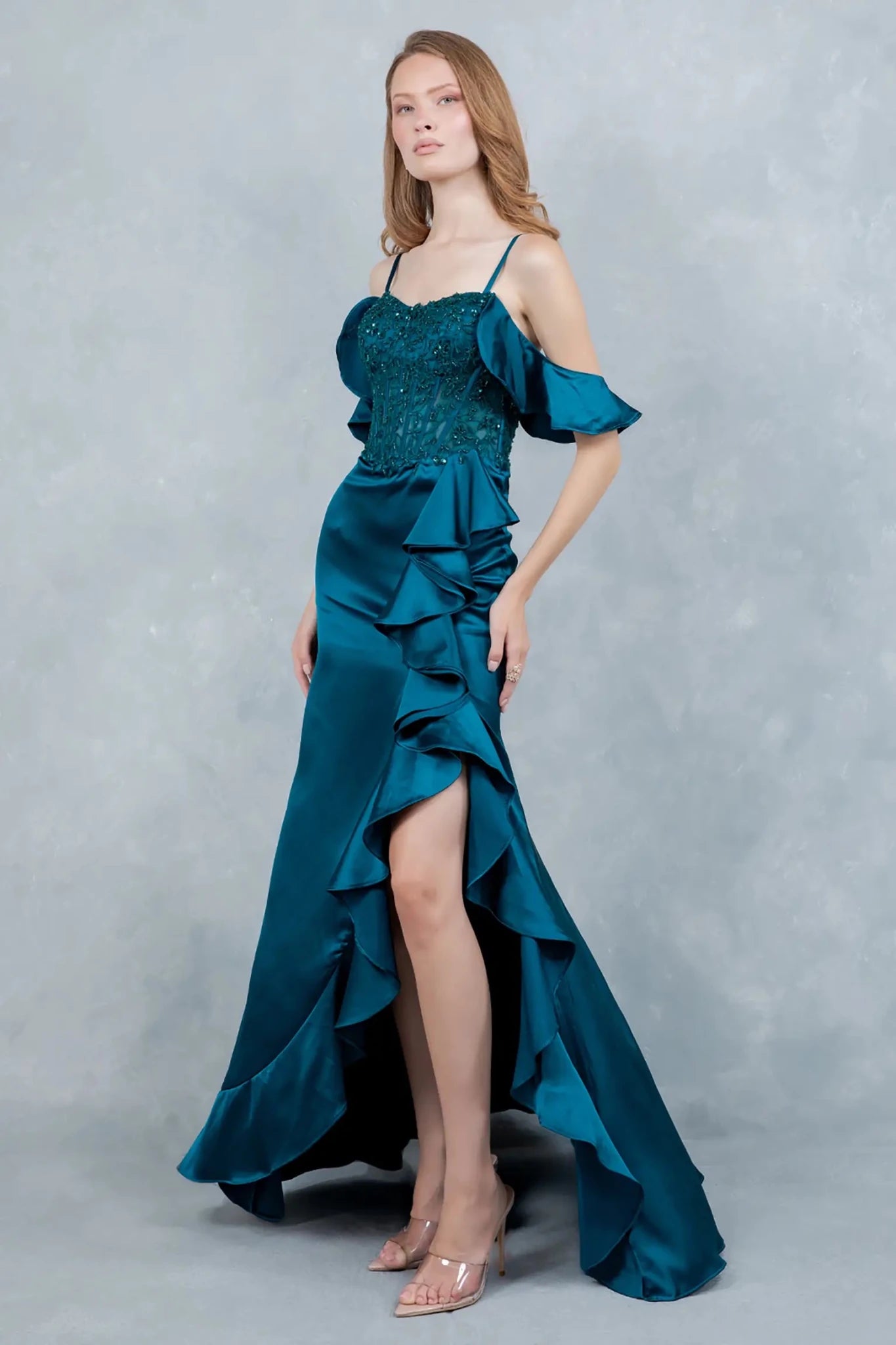 A full-length view of a woman wearing blue formal dress with a graceful train.