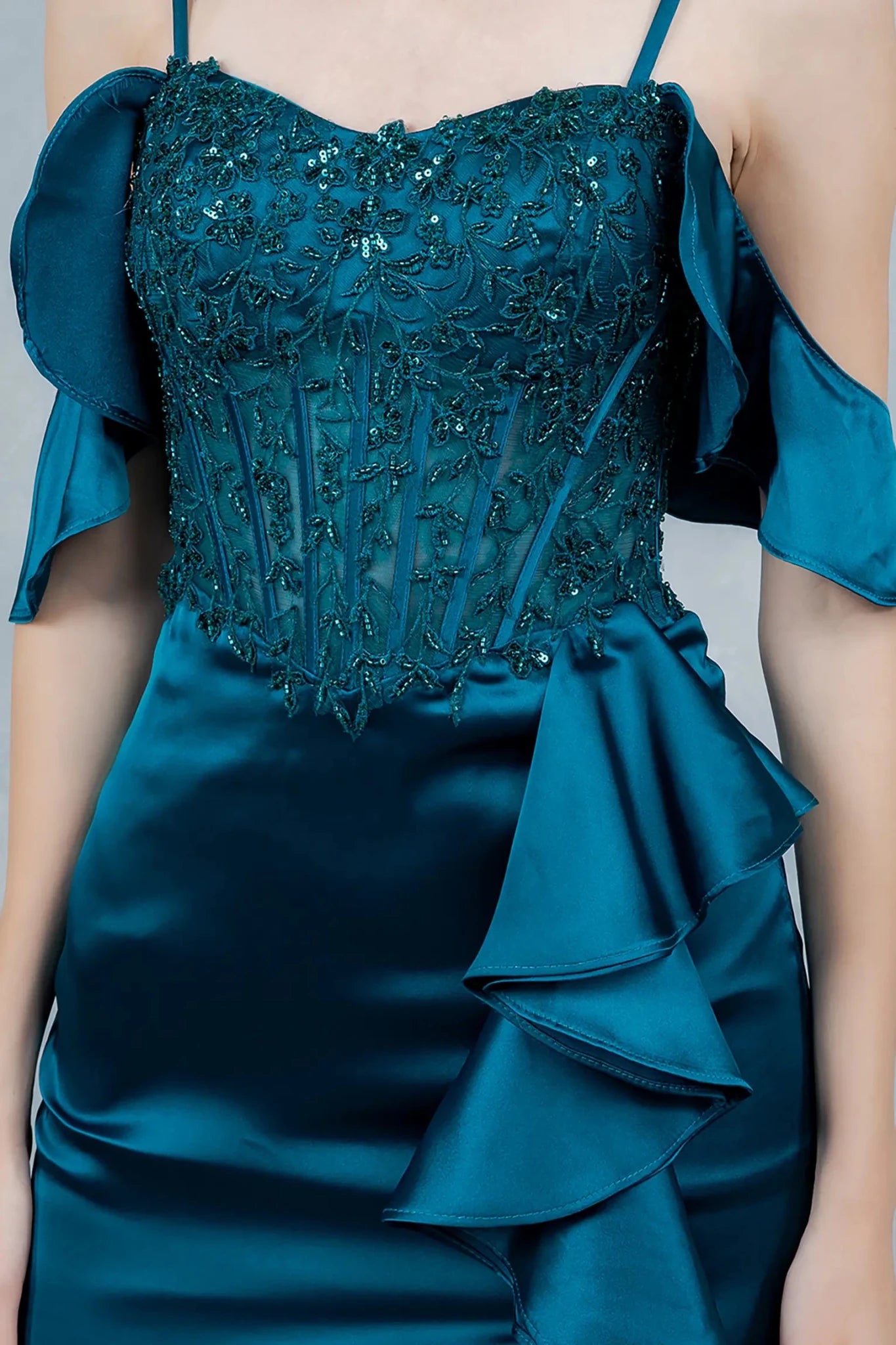 A close-up view of a woman wearing a blue lace corset bodice with illusion panel detailing.