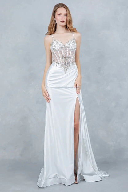A full-length view of a woman wearing silver formal prom dress with a lace-up corset and train.