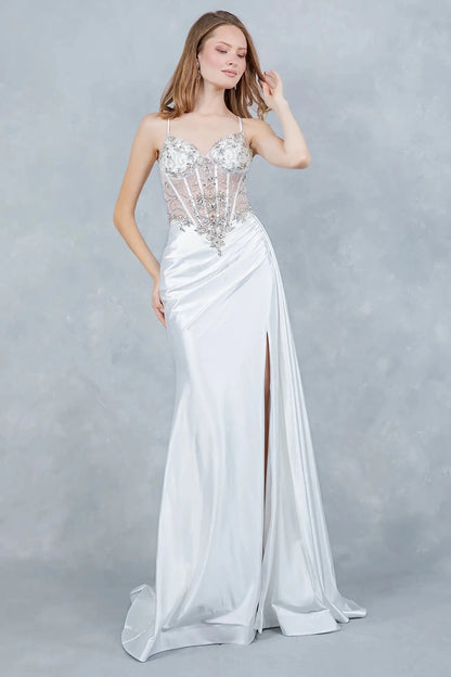 A full-length front view of a woman wearing a silver formal prom dress with a lace-up corset and train.