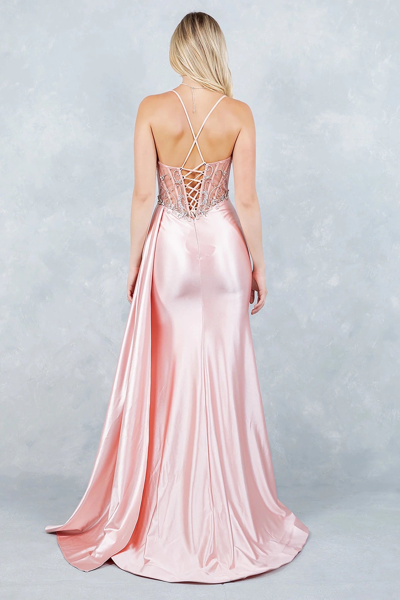 Blush prom dress featuring thin straps framing neckline with lace-up back for custom fit