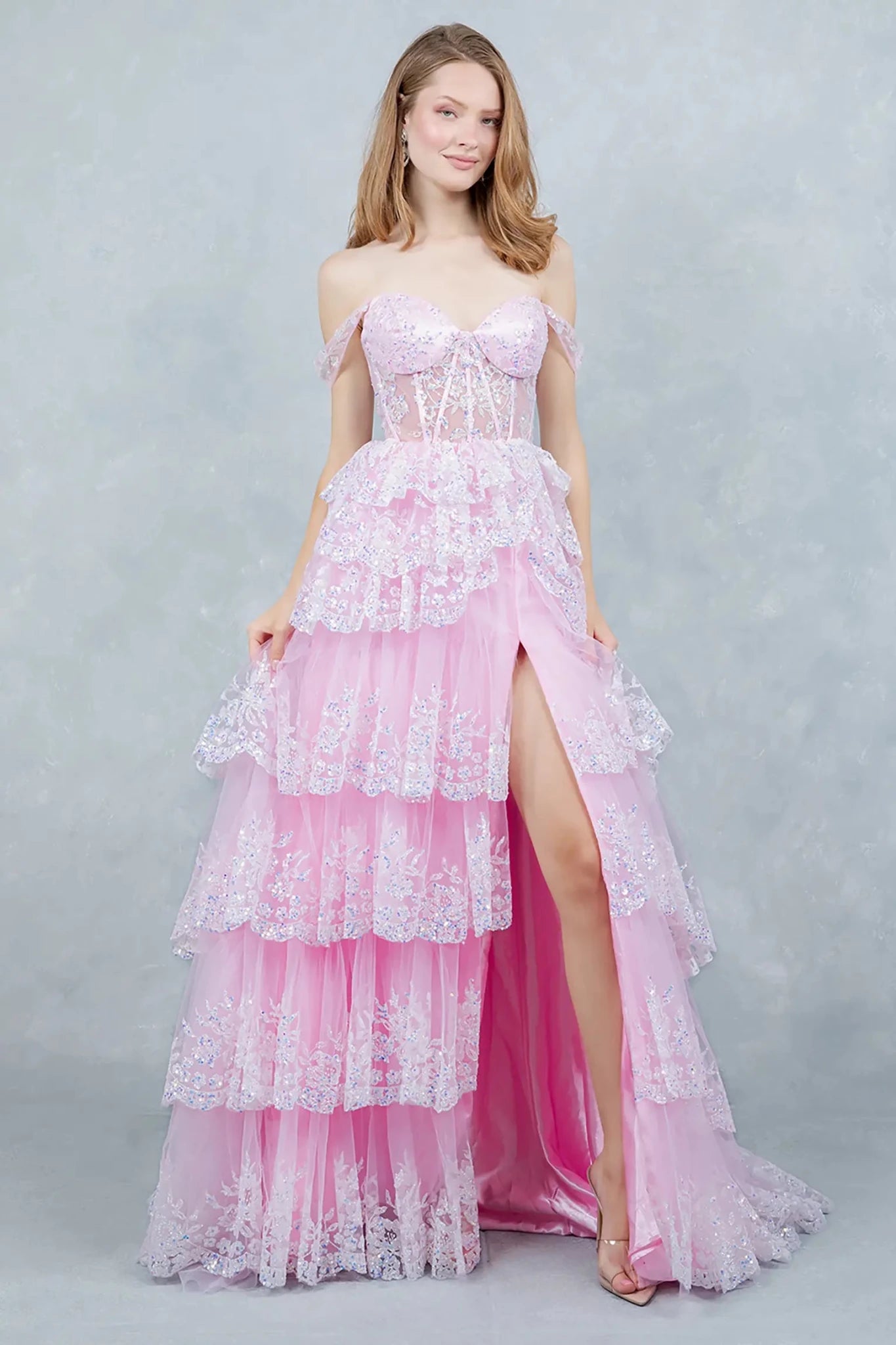 Full front view of a women wearing pink glitter tulle prom dress with lace corset bodice.