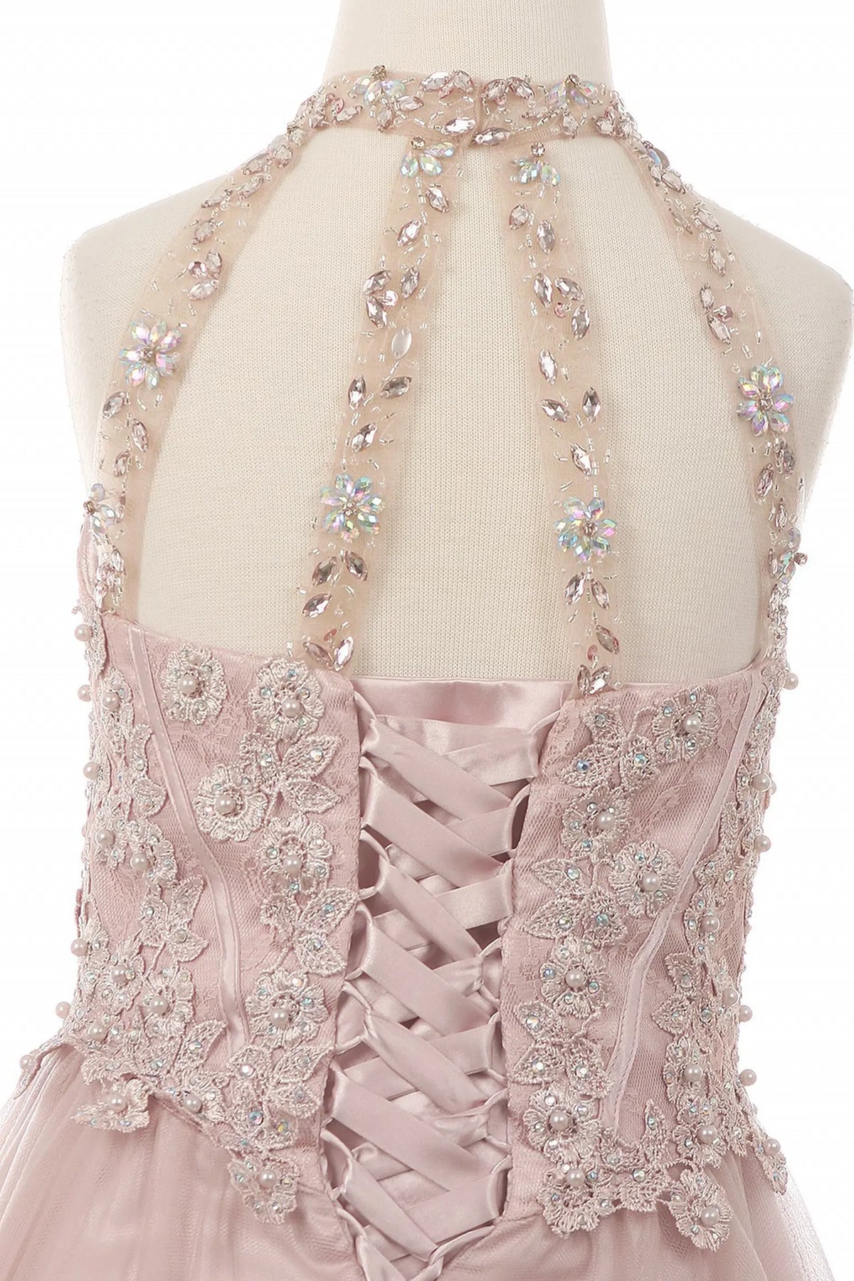 Detailed by crisscross lacing and a halter opening, the Dusty Rose kids party dress reveals its construction.