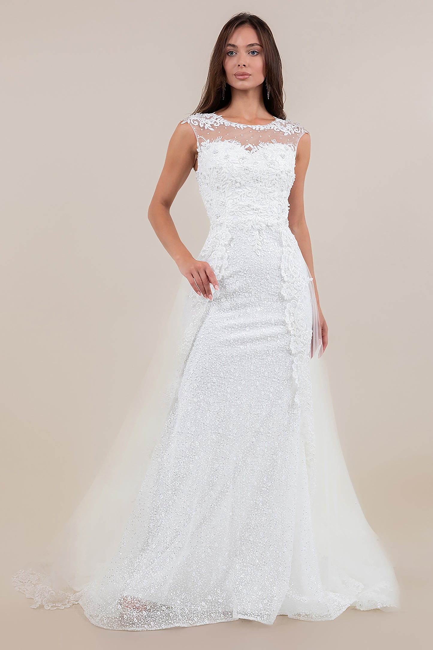 Woman wearing a white lace wedding dress against a beige background