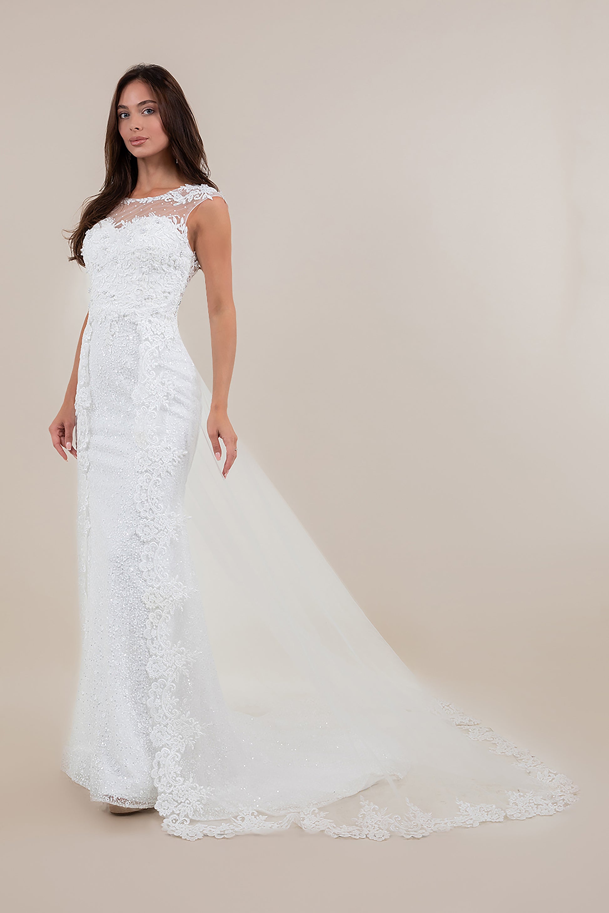 Woman wearing a white lace wedding dress against a beige background