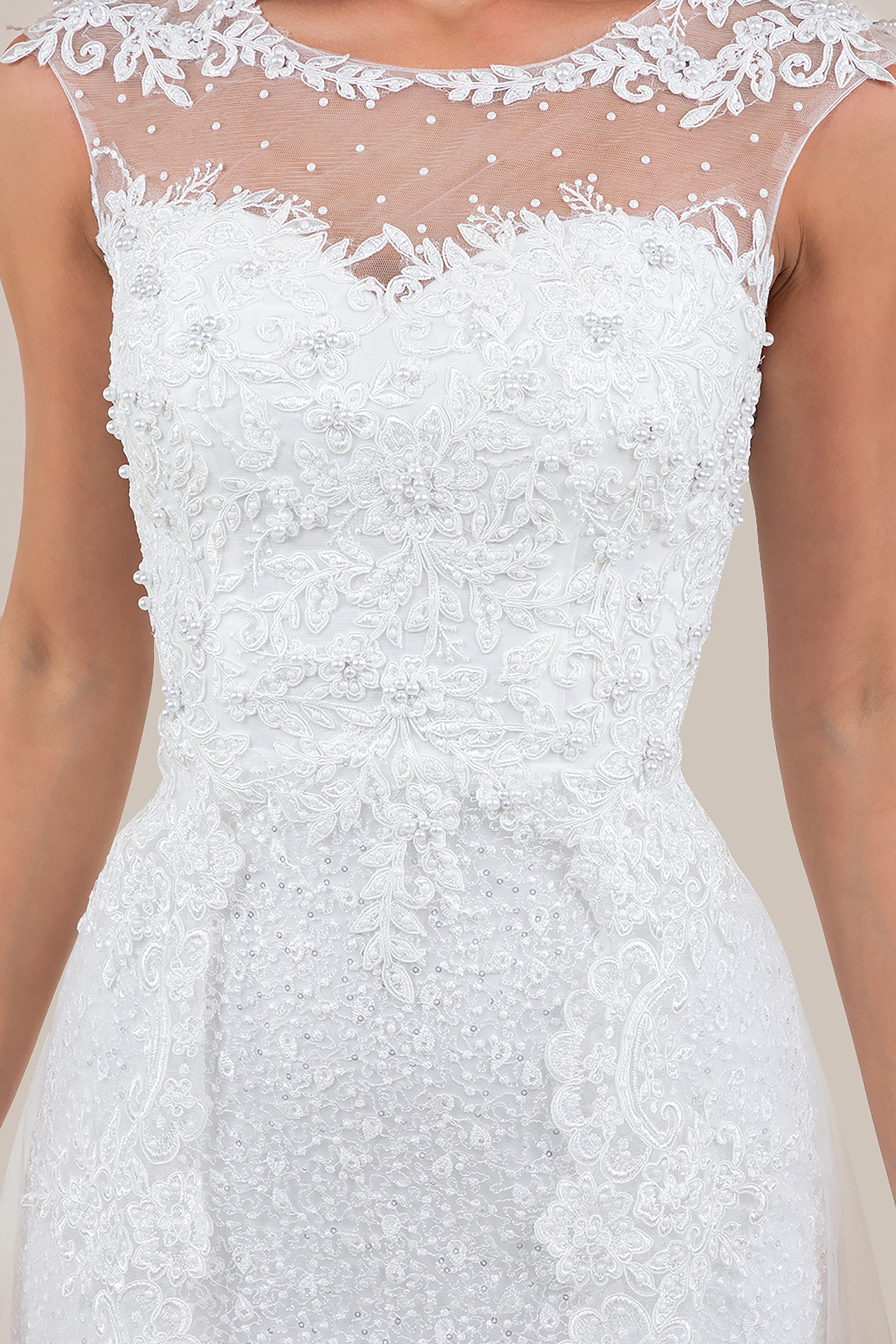 White lace dress with intricate detailing on a neutral background