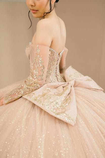 Side close-up view of a woman wearing mocha quinceañera dress highlighting layered tulle skirt, embroidered bodice, and corset silhouette.