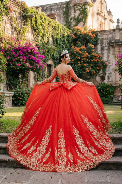 Back view of a woman wearing red quinceañera dress with voluminous glitter tulle skirt, lace-up corset closure, and gold embroidered accents.
