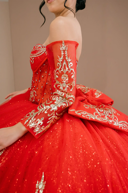 Side close-up view of a woman wearing red quinceañera dress highlighting glitter tulle layers, embroidered bodice, and corset silhouette.